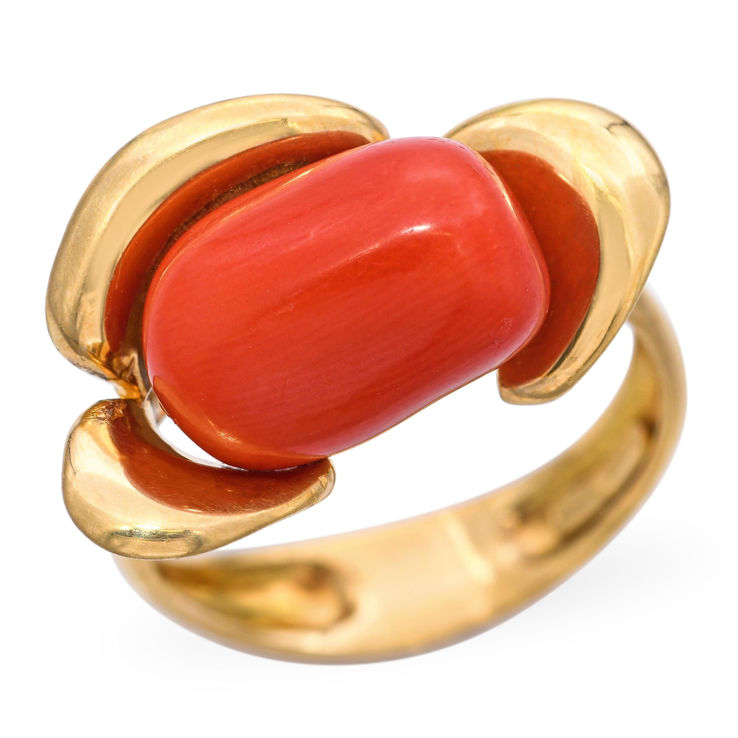 Anello d'epoca in oro giallo 18 carati con un bellissimo corallo intagliato al centro di un delicato motivo floreale. La ricca montatura in oro esalta la calda tonalità naturale del corallo, creando un pezzo pieno di fascino organico ed eleganza