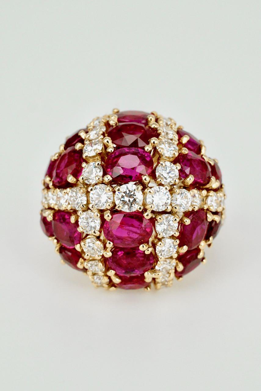 A vintage 18K yellow gold ruby and diamond bombe ring.  This spectacular retro ring consists of a domed cluster of 18 oval rubies and 43 brilliant cut diamonds claw set on a split double rope twist wire shank - a bold colour statement, this stunning