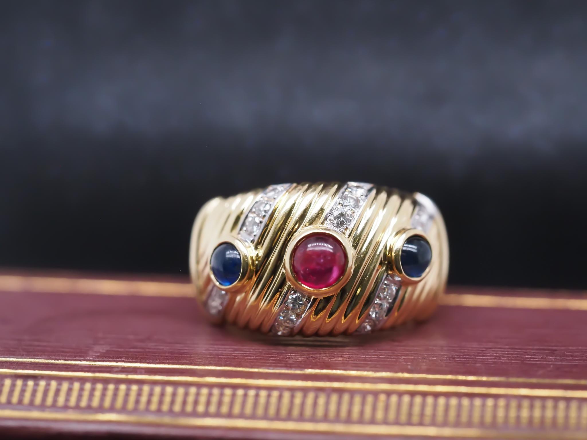 Year: 1990s

Item Details:
Ring Size: 8.75 (Sizable)
Metal Type: 18K Yellow Gold [Hallmarked, and Tested]
Weight: 11.8 grams

Diamond Details: .25ct total weight, Round Brilliant, Natural Diamond, F color, VS Clarity.

Side Stone Details: Ruby and
