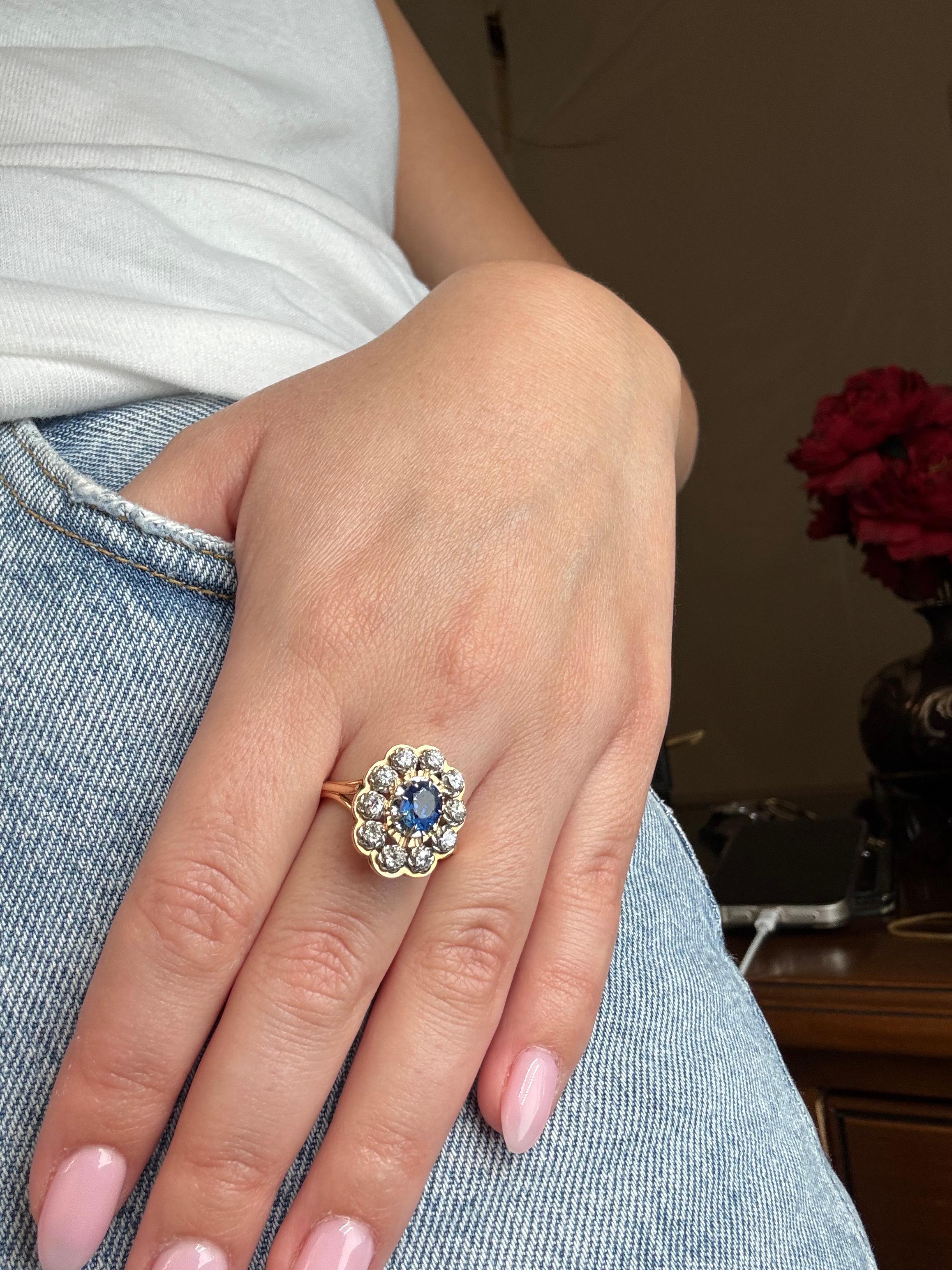 Dieser exquisite Damenring ist mit einem ovalen, lebhaften blauen Saphir von ca. 1,10 Karat besetzt, der in warmes 18 Karat Gelbgold (750‰) gefasst ist. Der zentrale Edelstein ist von zehn funkelnden Diamanten im Altminenschliff mit einem