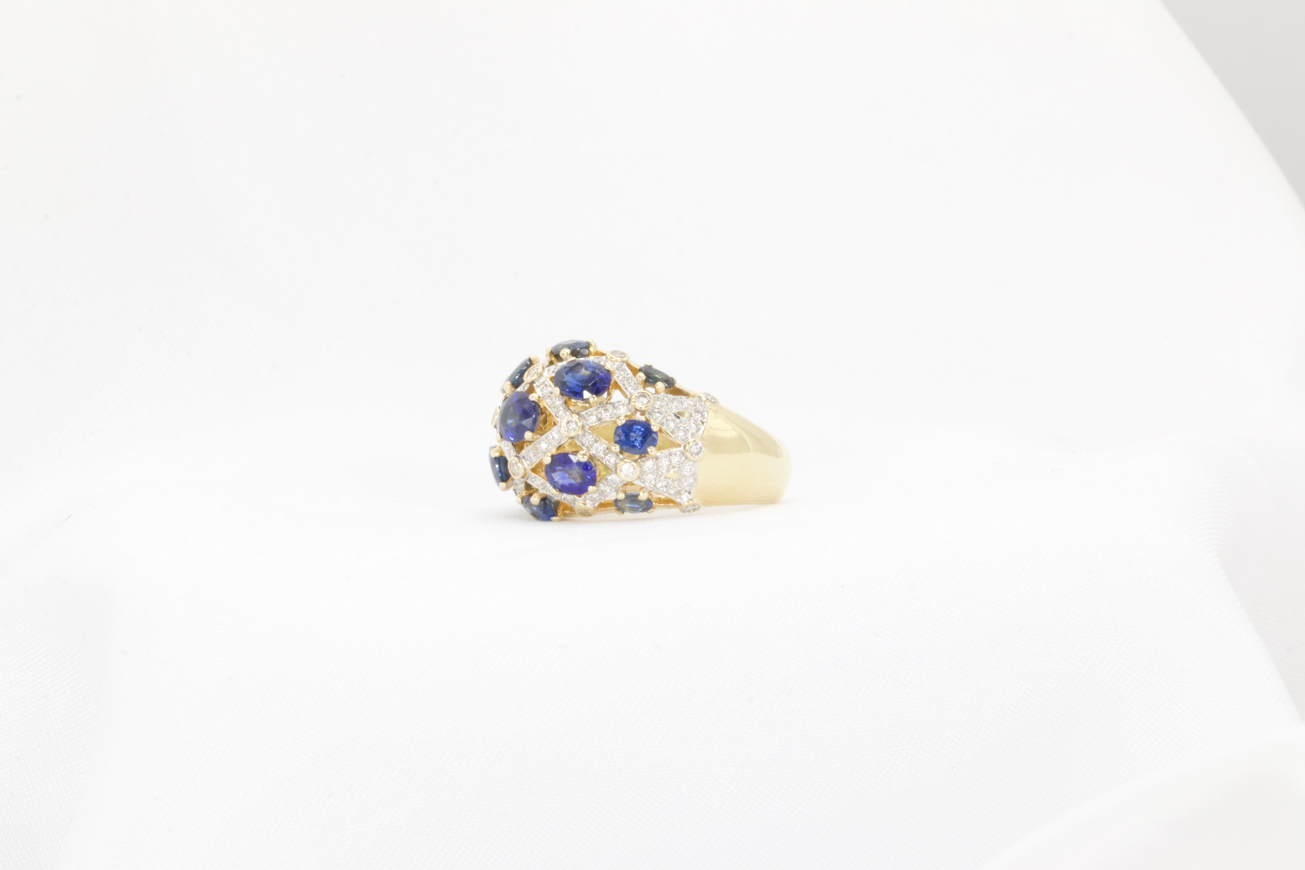 Dieser atemberaubende Vintage-Ring aus den 1970er Jahren ist aus 18 Karat Gelbgold gefertigt und besticht durch eine elegante Kombination aus Saphiren und Diamanten. Er präsentiert 13 ovale, natürliche, sattblaue Saphire mit einem Gesamtgewicht von