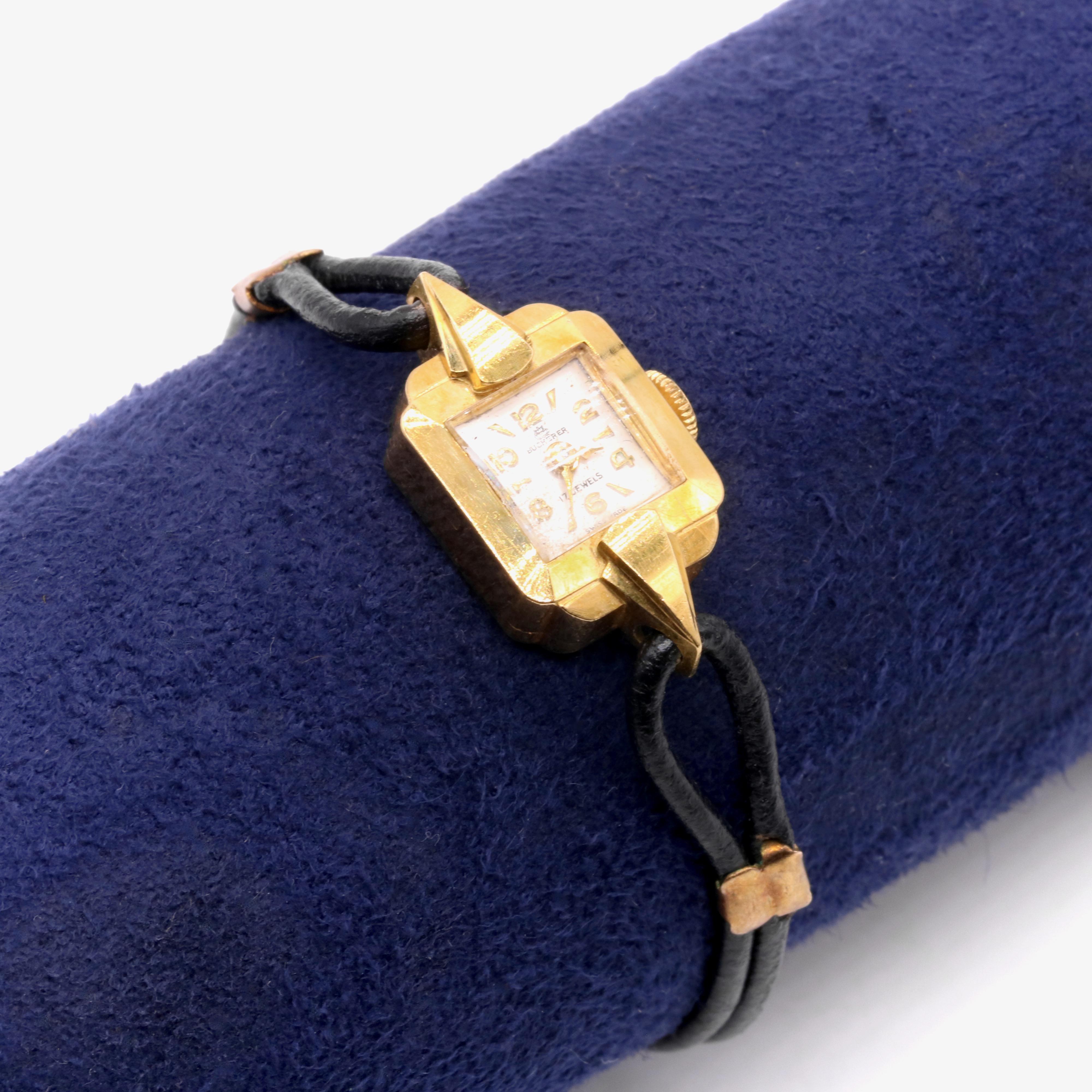 A ladies wristwatch in 18k yellow gold, to form a square watch case, with a silvered dial, sporting baton hour markers and gold Arabic numerals. 

This Bucherer watch is Swiss made, ensuring the highest quality. The silvered dial is a beautiful
