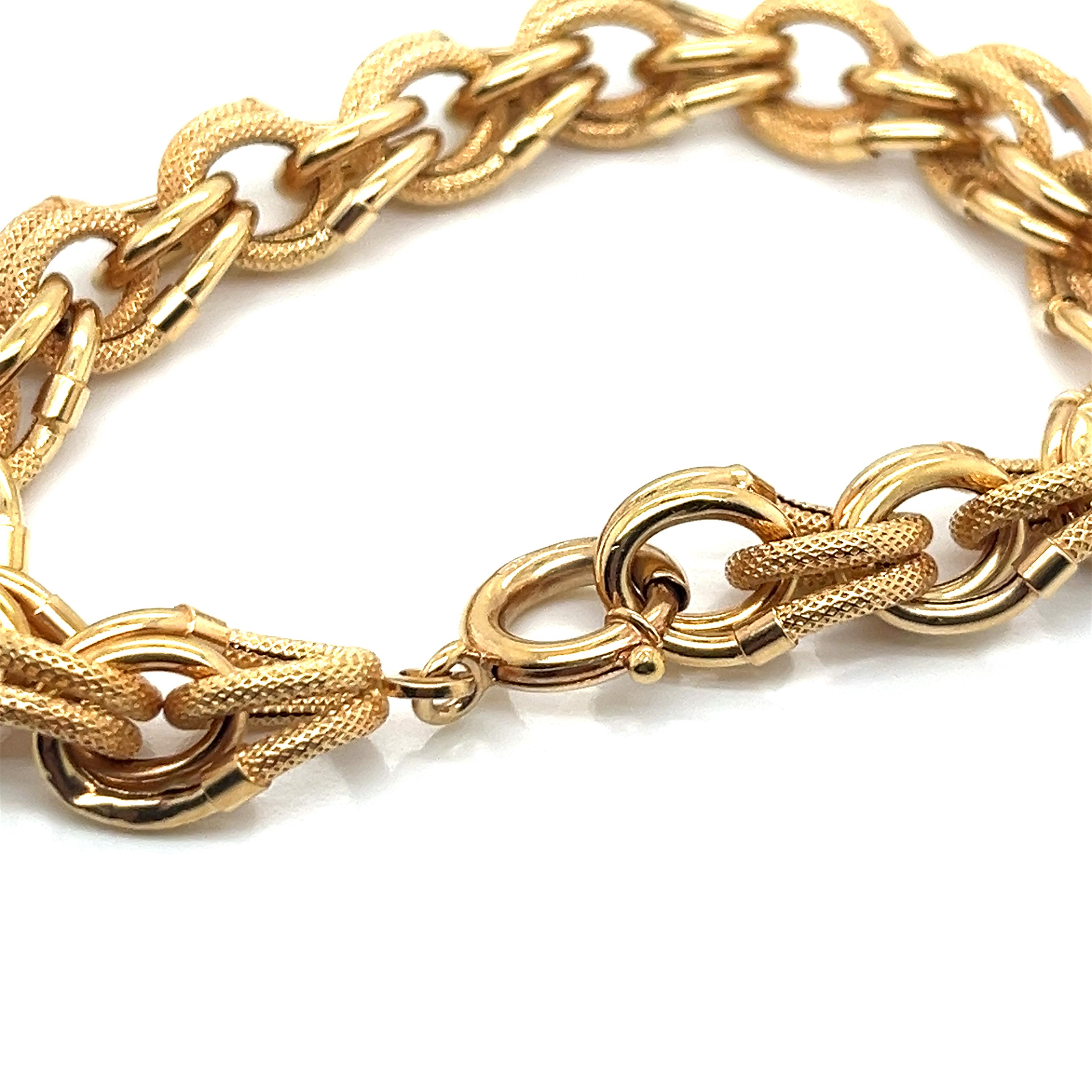 Dieses Vintage-Armband aus den 1980er Jahren besticht durch die Kombination von strukturierten und glänzenden Gliedern aus 18 Karat Gelbgold. Das Design zeichnet sich durch ein abwechselndes Muster aus glatten, polierten ovalen Gliedern aus, die mit