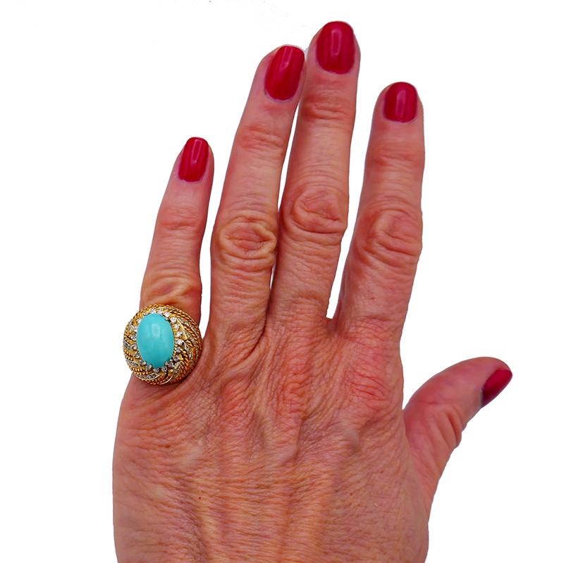Cocktail ring featuring a beautiful oval cabochon turquoise set in 18 karat yellow gold and accented with single cut diamonds (I-J color, VS2 clarity, approximately 0.70 carat total weight). The diamonds are set in white gold.
Measurements: ¾” x ¾”