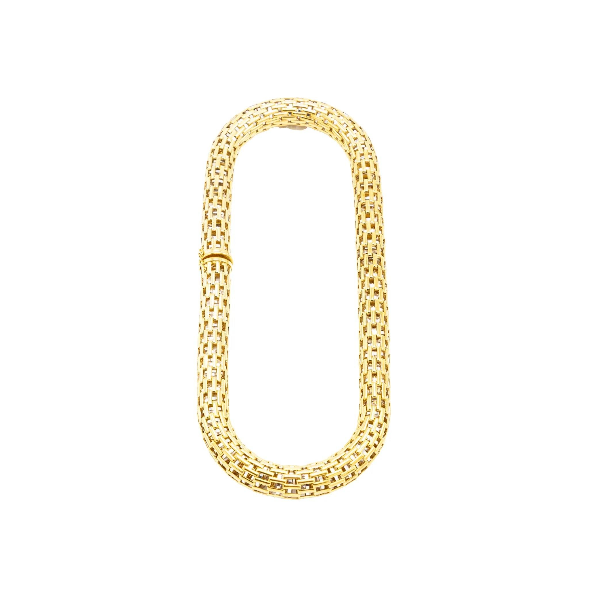 Este collar vintage, una pieza atrevida y atemporal de los años 80, está fabricado en oro amarillo macizo de 18 quilates con un diseño tejido bellamente articulado. Su estructura flexible abraza el escote con una refinada fluidez arquitectónica,