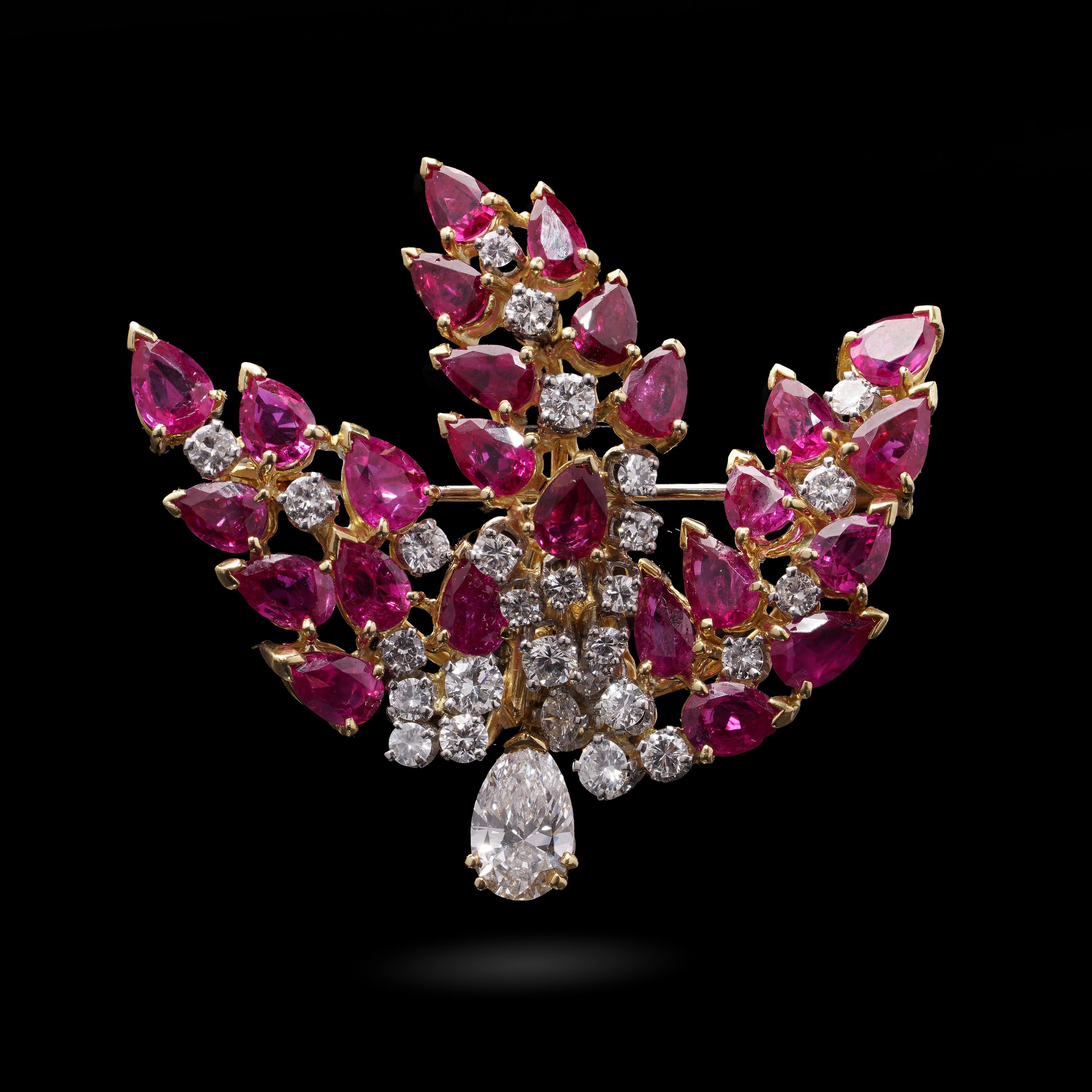 A bold and elegant mid-20th century brooch, masterfully composed in a dramatic foliate spray design. This certified piece is crafted in 18kt yellow and white gold and showcases exceptional quality natural gemstones: unheated Burmese rubies and