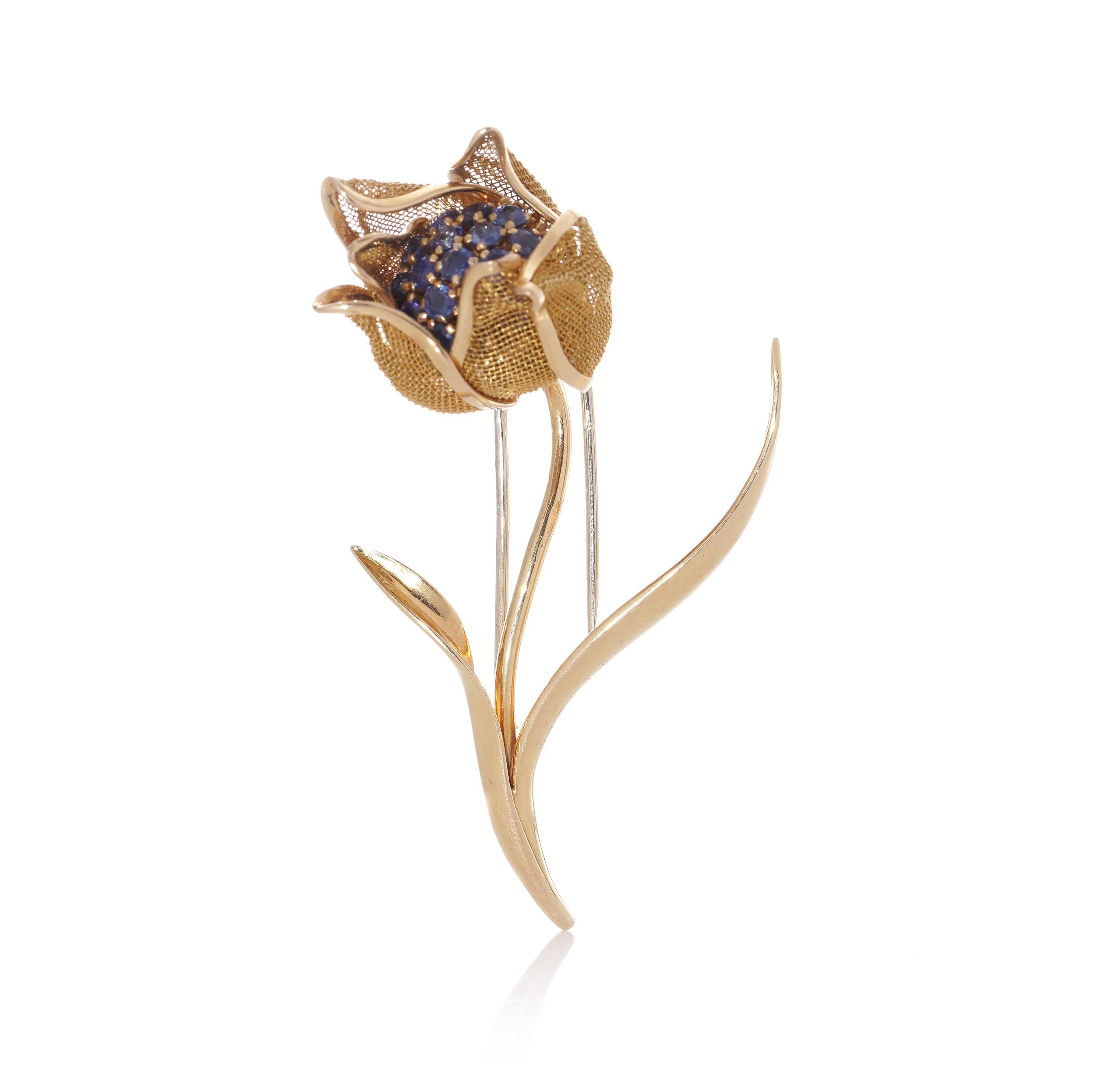 This exquisite brooch showcases a captivating floral design crafted from 18k yellow gold, featuring hinged mesh petals meticulously adorned with blue sapphires totaling an estimated weight of 1.52 carats. Originating from France circa the 1940s,