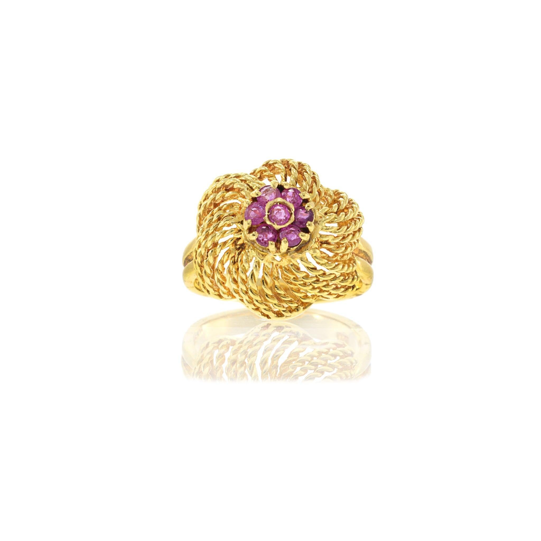 Bold and unique, this Retro Era ring showcases the intricate craftsmanship of the mid-20th century. Crafted in 18KT yellow gold, this piece features a twisted, spiral design that captures the dynamic spirit of the era. At its center is a vibrant