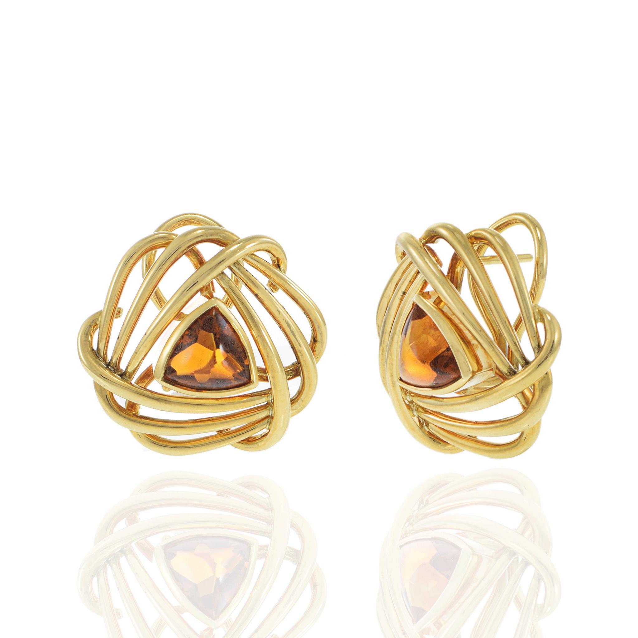 Striking in form and color, these vintage 1970s earrings feature warm golden topaz cut in a rare trillion shape, cradled in open spiral frames of high-polish 18KT yellow gold. The sculptural swirl design captures the bold creativity of the era,