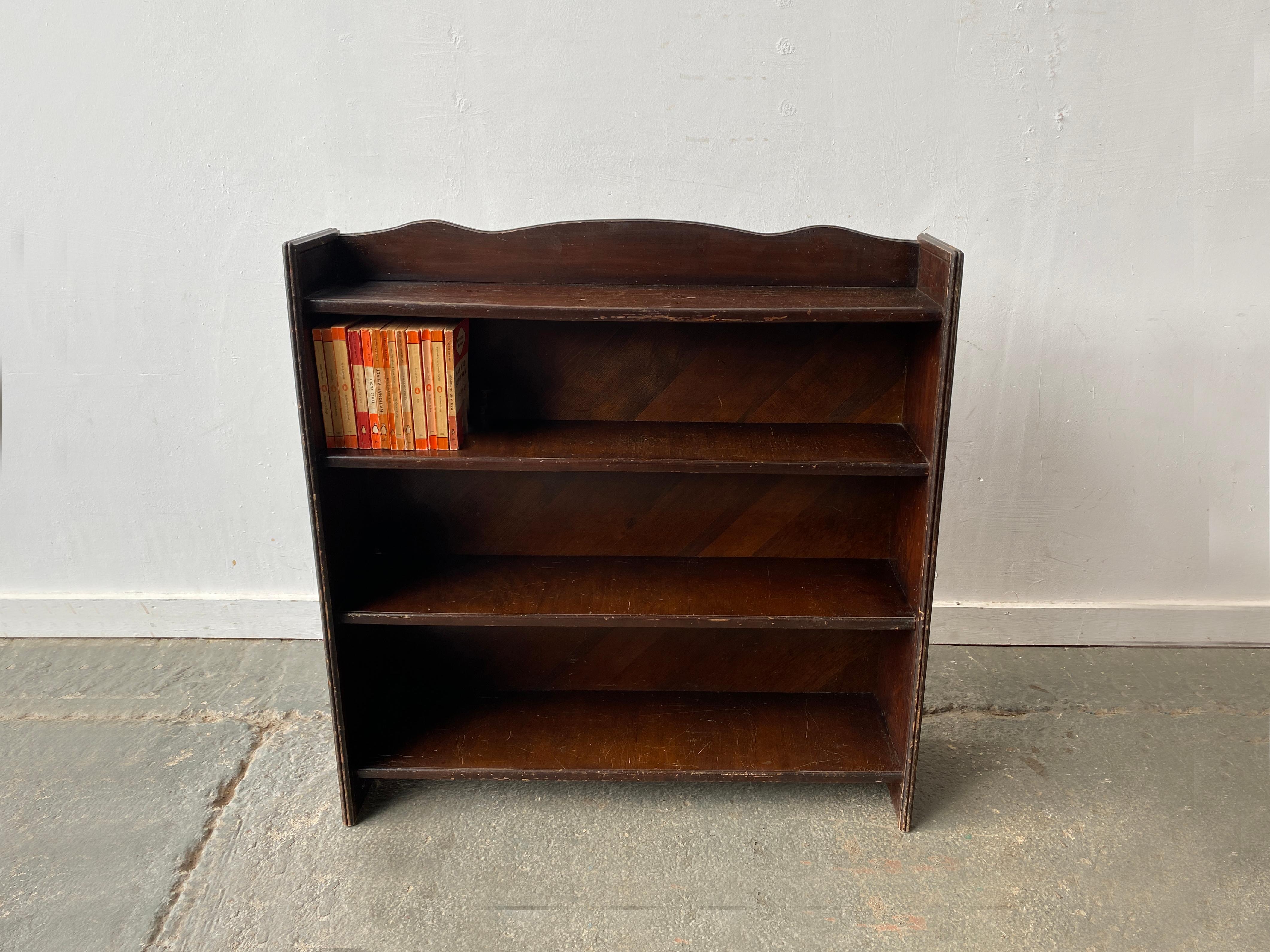 A free-standing open fronted vintage bookcase with 4 shelves. The two end supports taper towards the top. Made from dark stained solid pine.

Size 
Width 92cm
Depth at base 24cm
Depth at top 18cm
Height 94cm

Height available for books as