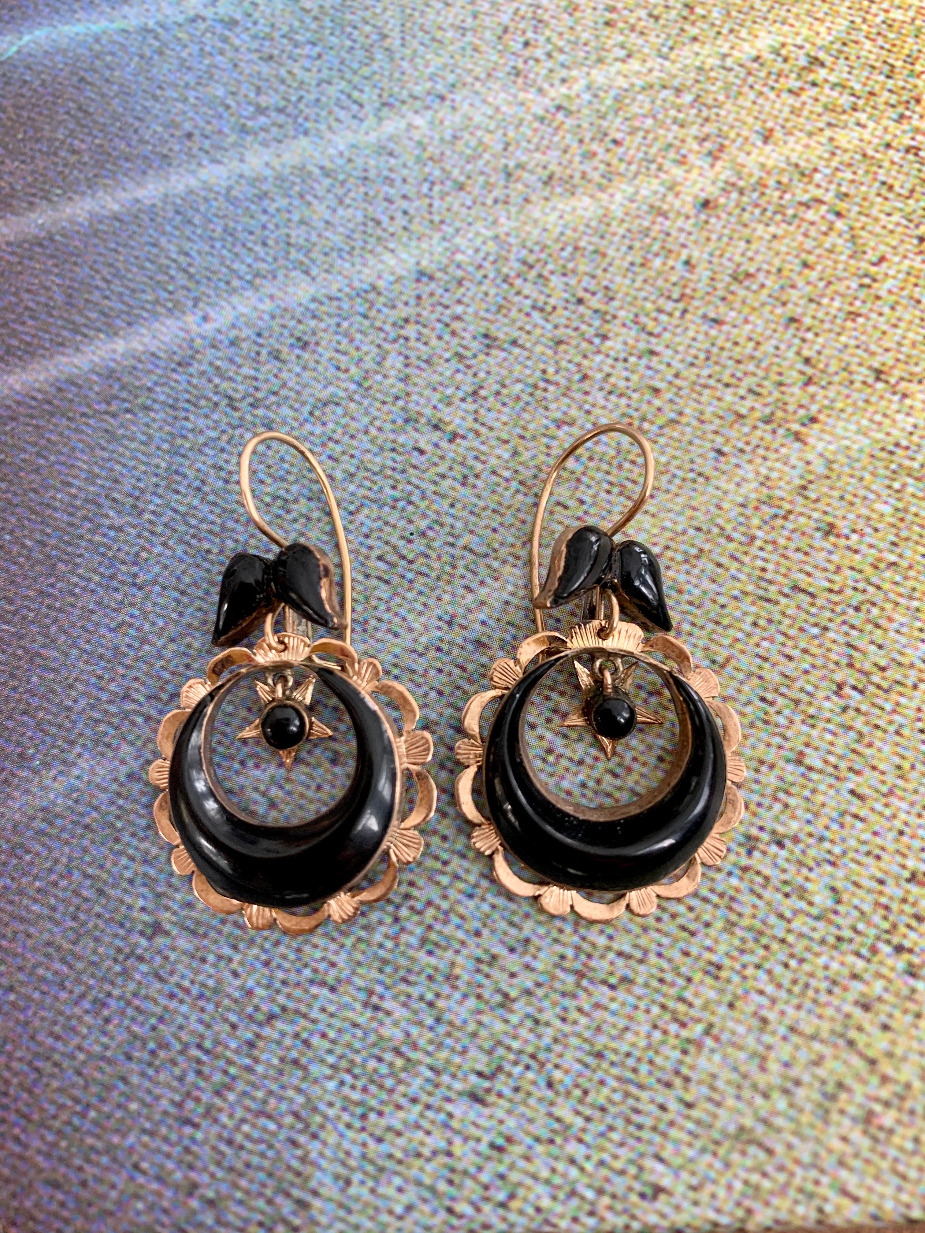 These vintage earrings are 1920s-1930s era and feature a circle of black Onyx which is surrounded by 14 karat yellow Gold. There is a star hanging inside the the circle.  Inside the star there is a cabochon black Onyx.  The ear wires are also
