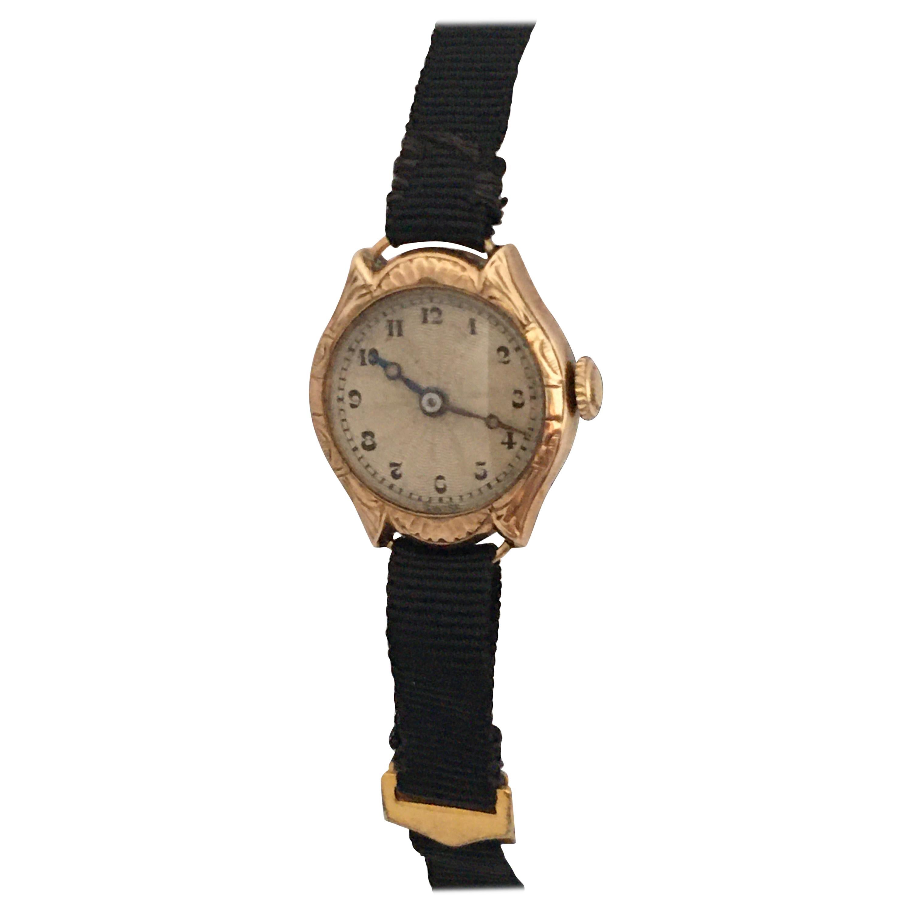This beautiful vintage gold ladies hand winding watch is working and it is recently been serviced and runs well, (good time keeping). Visible signs of ageing and wear. the silvered dial has aged as shown. It is fitted with a black cloth strap. as
