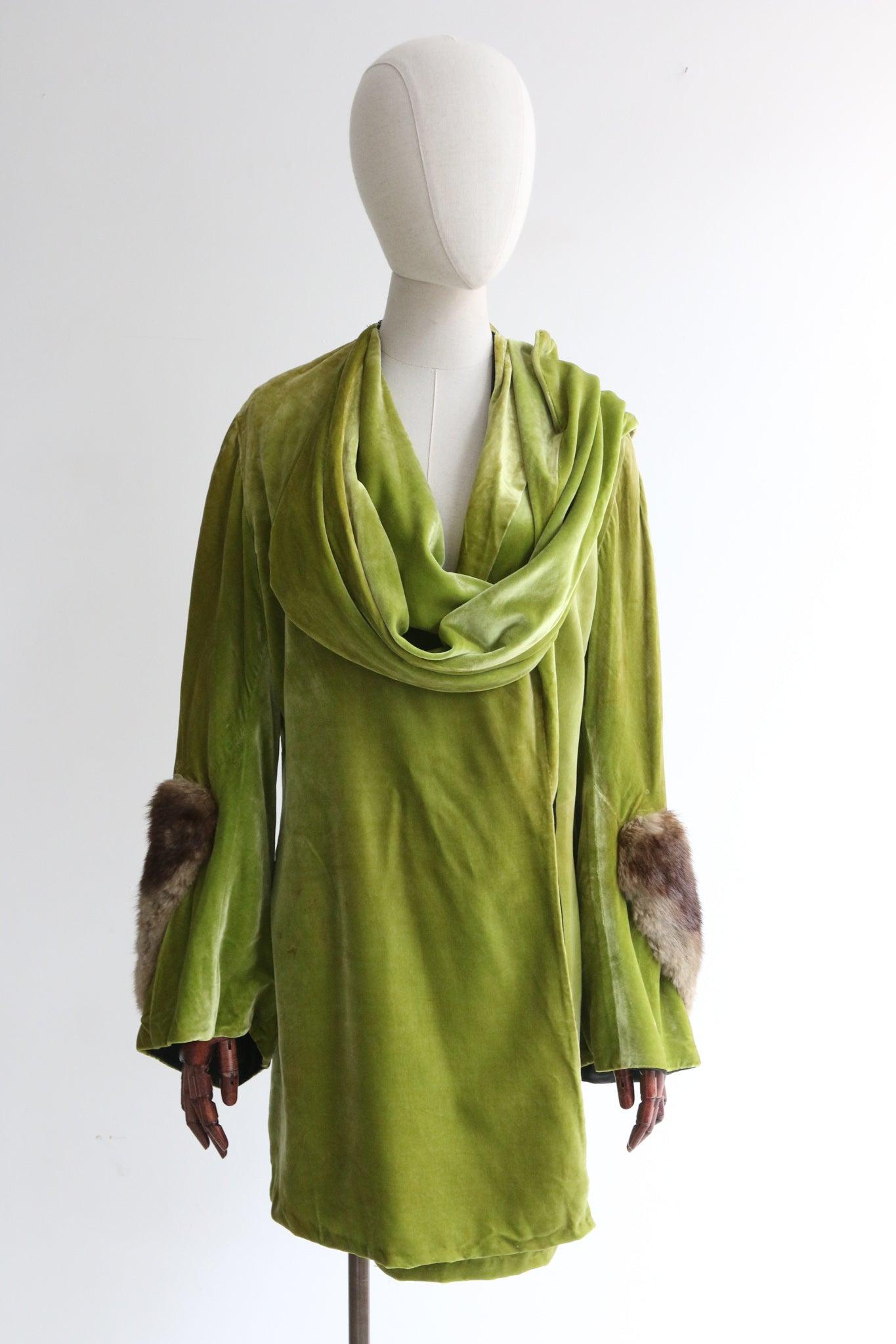 Made in the most delicious shade of apple green silk velvet, this original 1920's French coat, is a rare piece to behold.

Her elegant shoulder line is set off by a cross over front design from which a mock neck scarf hangs along the right hand