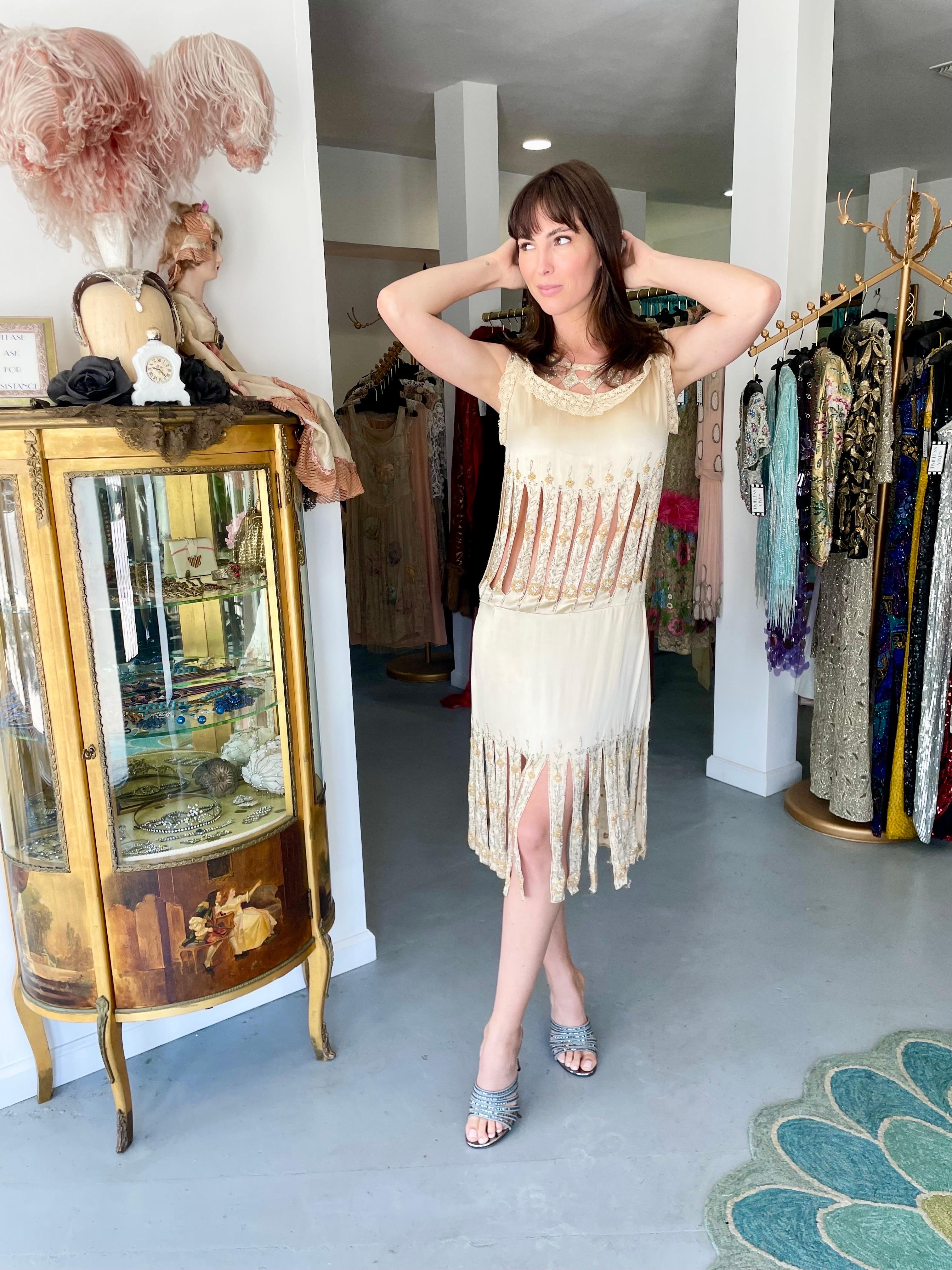 Untouched by time, this incredibly rare 1920's candlelight cream silk dance dress still casts its magical spell. This exceptional Art Deco beauty is fashioned in luxurious mid-weight silk satin that has been lavishly embellished with hundreds of