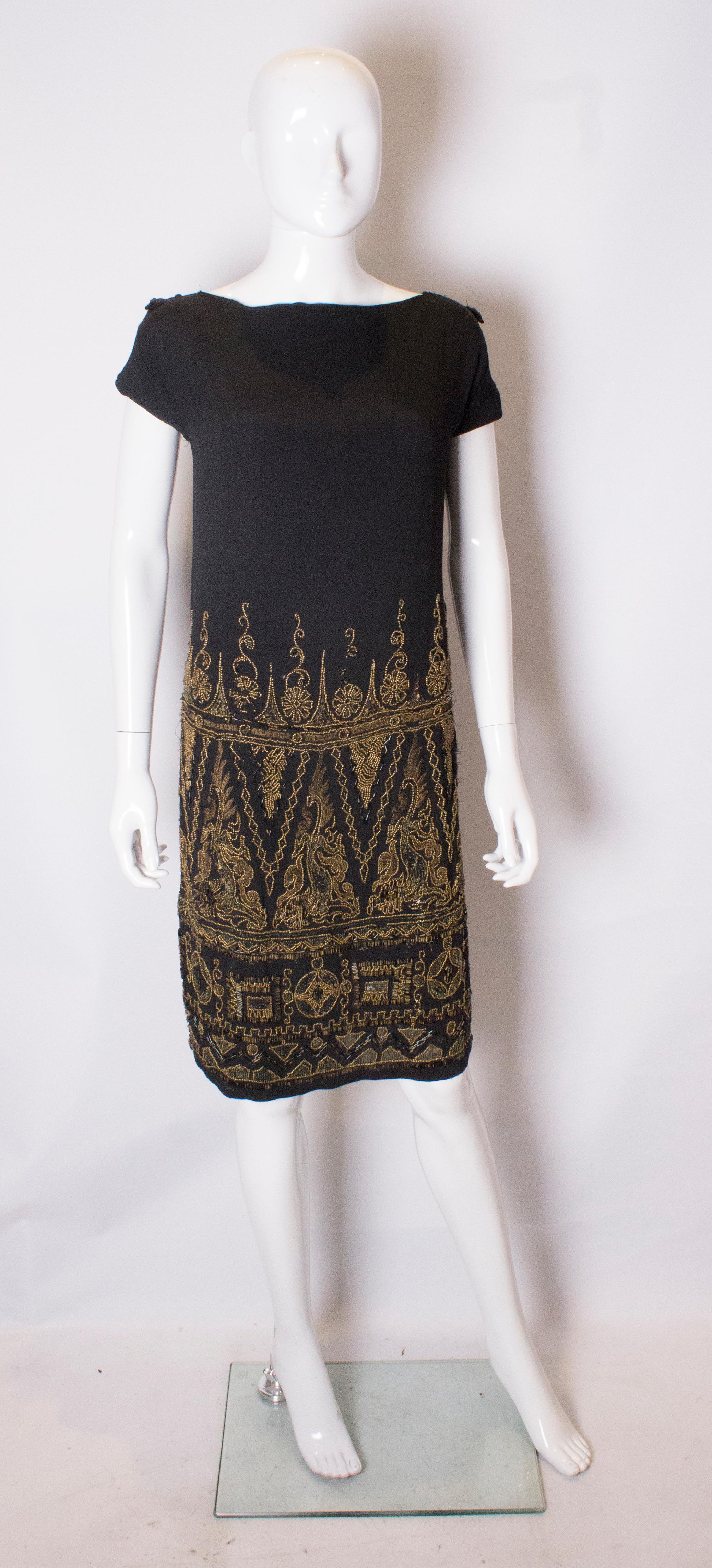 A lovely dress from the 1920s.. The dress is made of a black fabric with wonderful bead work in an attractive pattern. It has 20'' slits on either side and sadly some damage.