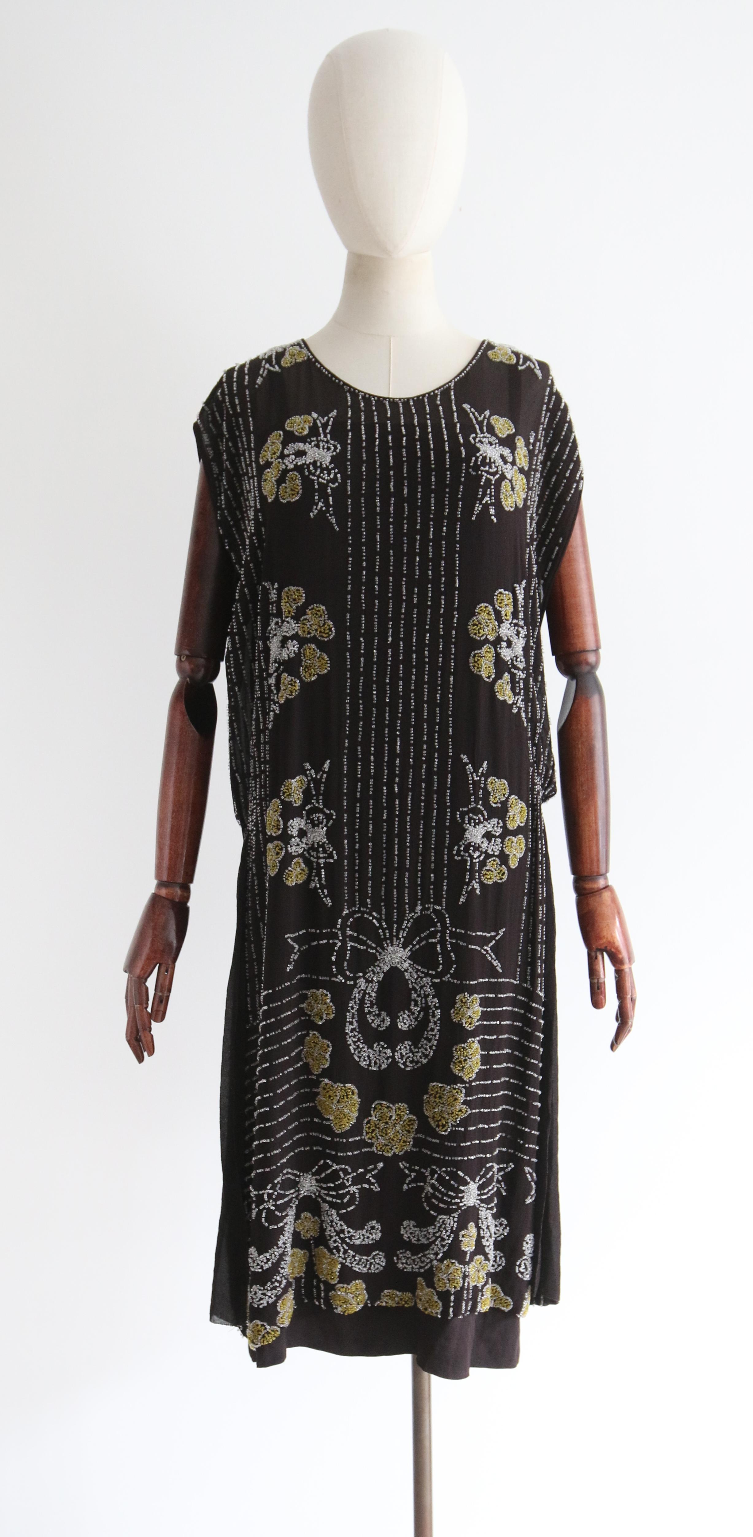 Full of opulent original details, rendered in the most luxurious fashion, this rare 1920's piece is a beauty to behold. On a base of black silk chiffon and embellished with glass beads, this vintage 1920's showcases the incredible craftsmanship of