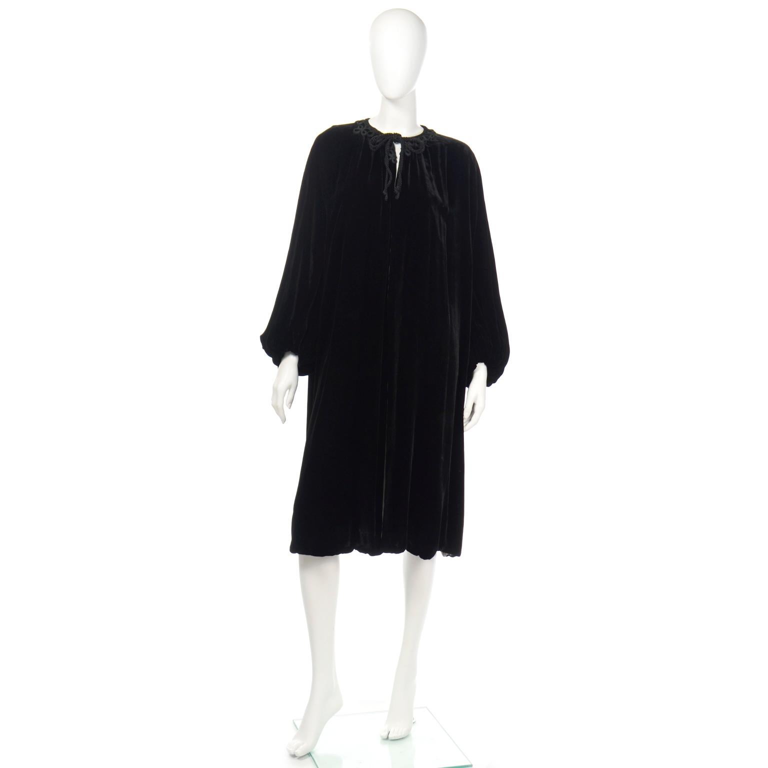 This is a luxurious silk velvet 1920's evening coat with an open front and black rope tie at the neck. We especially love the beautiful soutache trim. The pretty bubble slight balloon sleeves have elastic cuffs, and add give the piece lovely