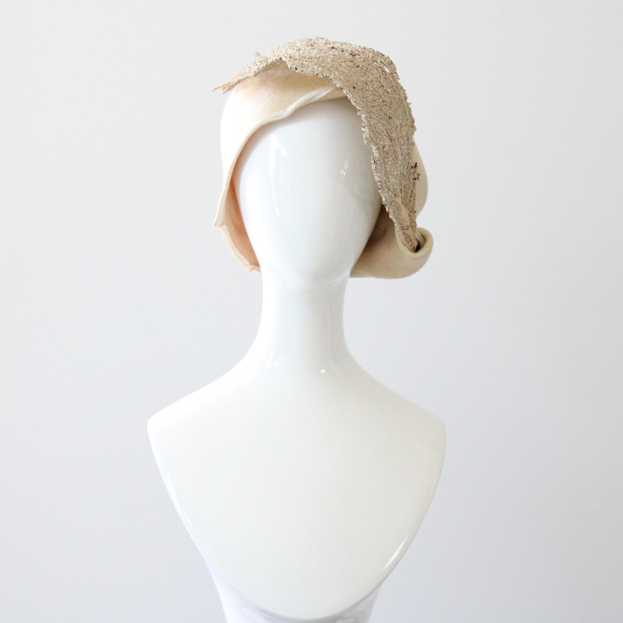 Dieser seltene und unglaublich komplizierte Cloche-Hut aus cremefarbenem Filz aus den 1920er Jahren, der mit echten Seemannsfächer-Zweigen verziert ist, die zart mit cremefarbener Farbe bemalt wurden, ist ein prächtiges Stück, das Sie in Ihrer