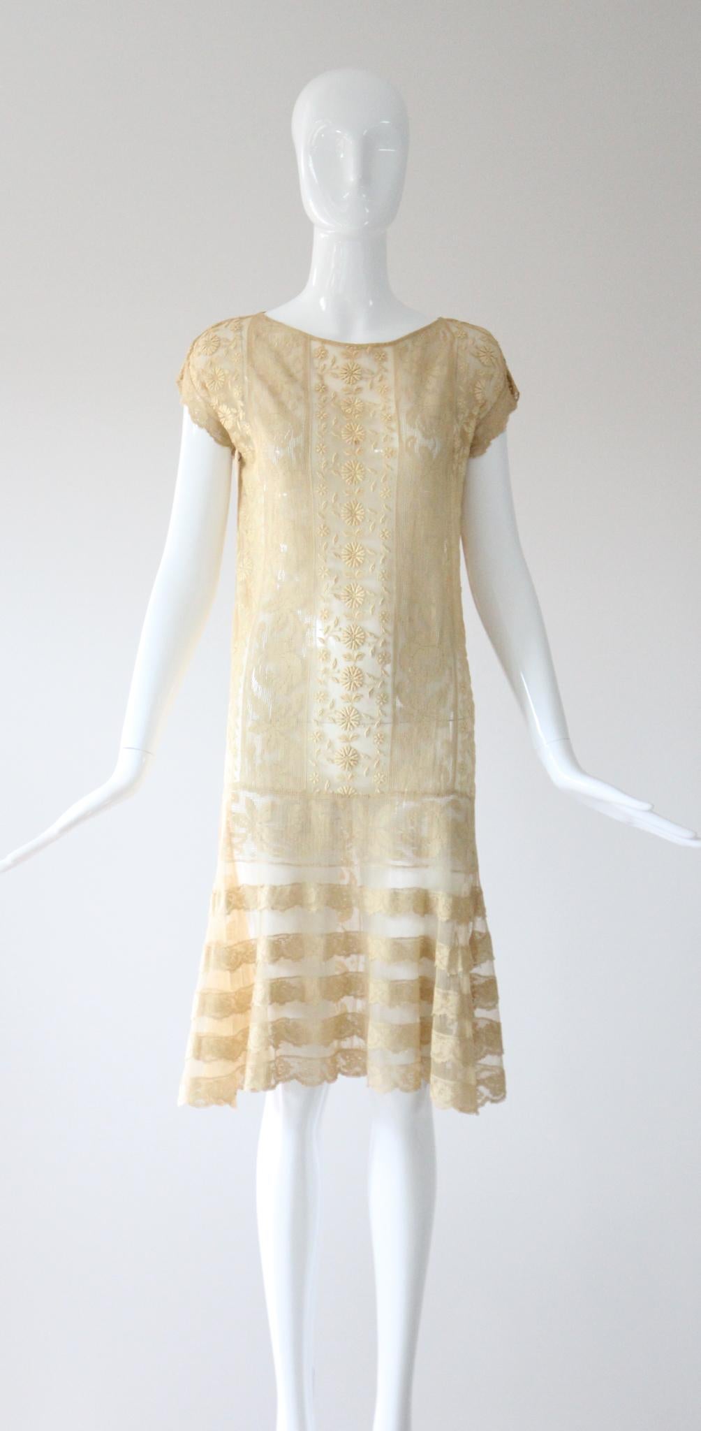 Full of opulent original details, rendered in the most luxurious fashion, this rare 1920's piece is a beauty to behold.

The rounded neckline of the dress, is framed by a simple shoulder line which sets off the short length sleeves, edges with