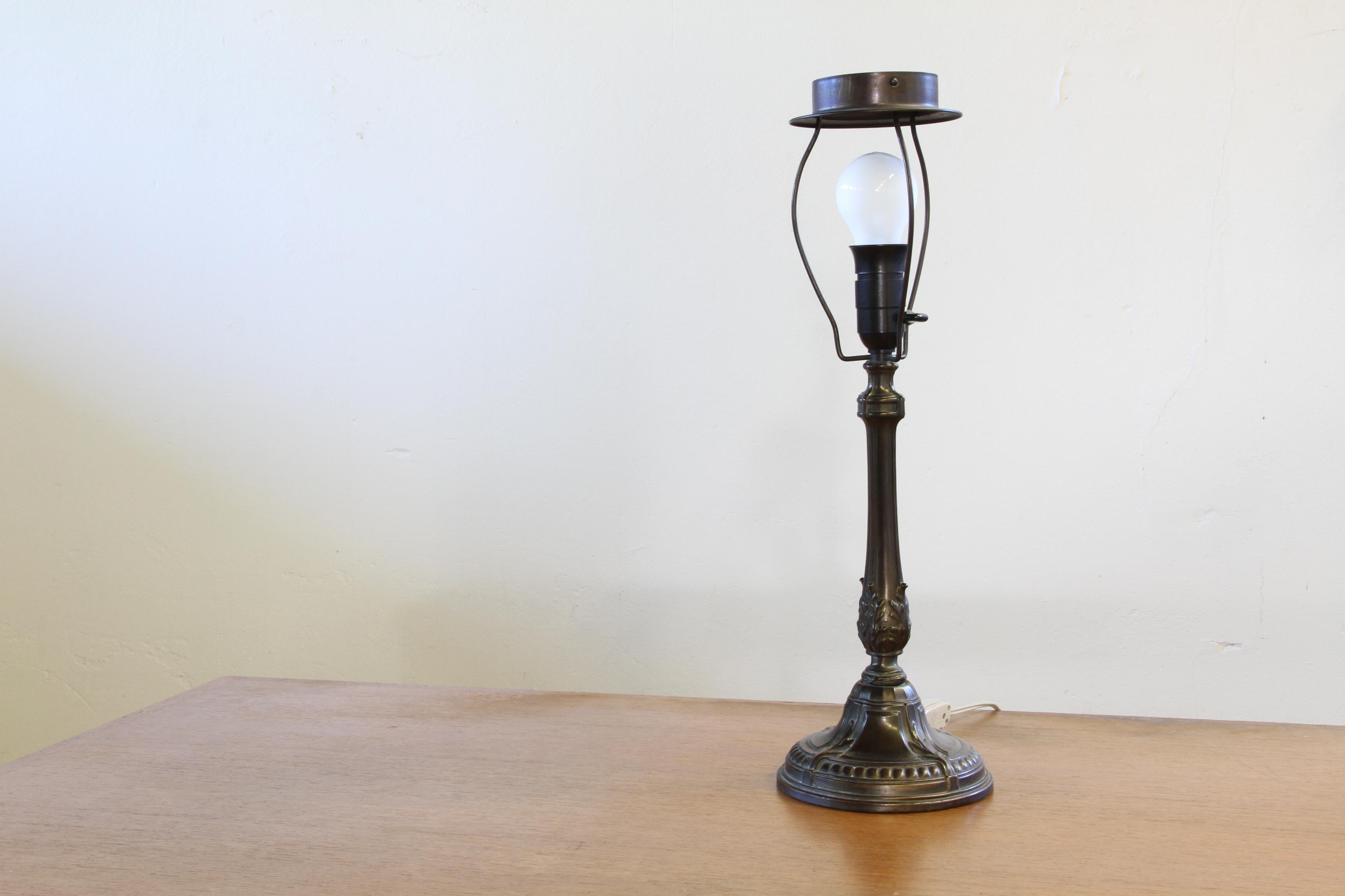 A rare Danish table lamp in the style of Just Andersen’s Diskometal designs, this 1920s piece captures the refined beauty and functionality characteristic of Nordic and Scandinavian design of the time. Its form is both minimalist and sculptural,