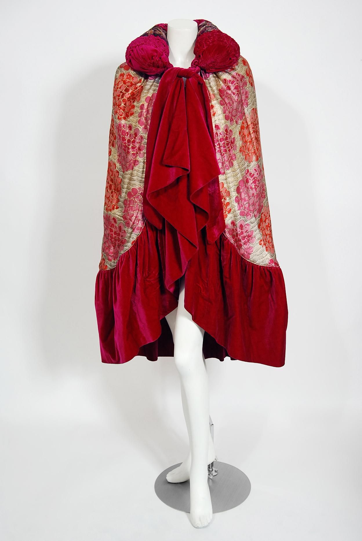 A gorgeous French metallic hydrangea floral print lamé & magenta silk-velvet evening cape dating back to the mid 1920's. Evening capes from the art-deco era remain a perennial favorite, perhaps because no other period combined such opulence with