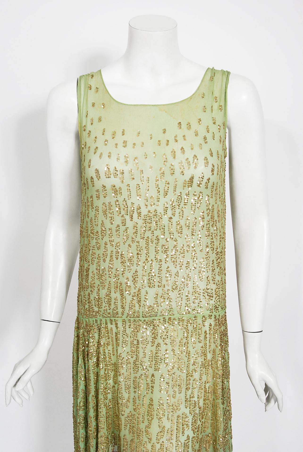 A truly breathtaking French couture sparkling mint-green beaded flapper dance dress dating back to the mid 1920's. The magical mint-green color mixed with the unique gold deco clustered micro-sequins touches a deep chord in our collective aesthetic