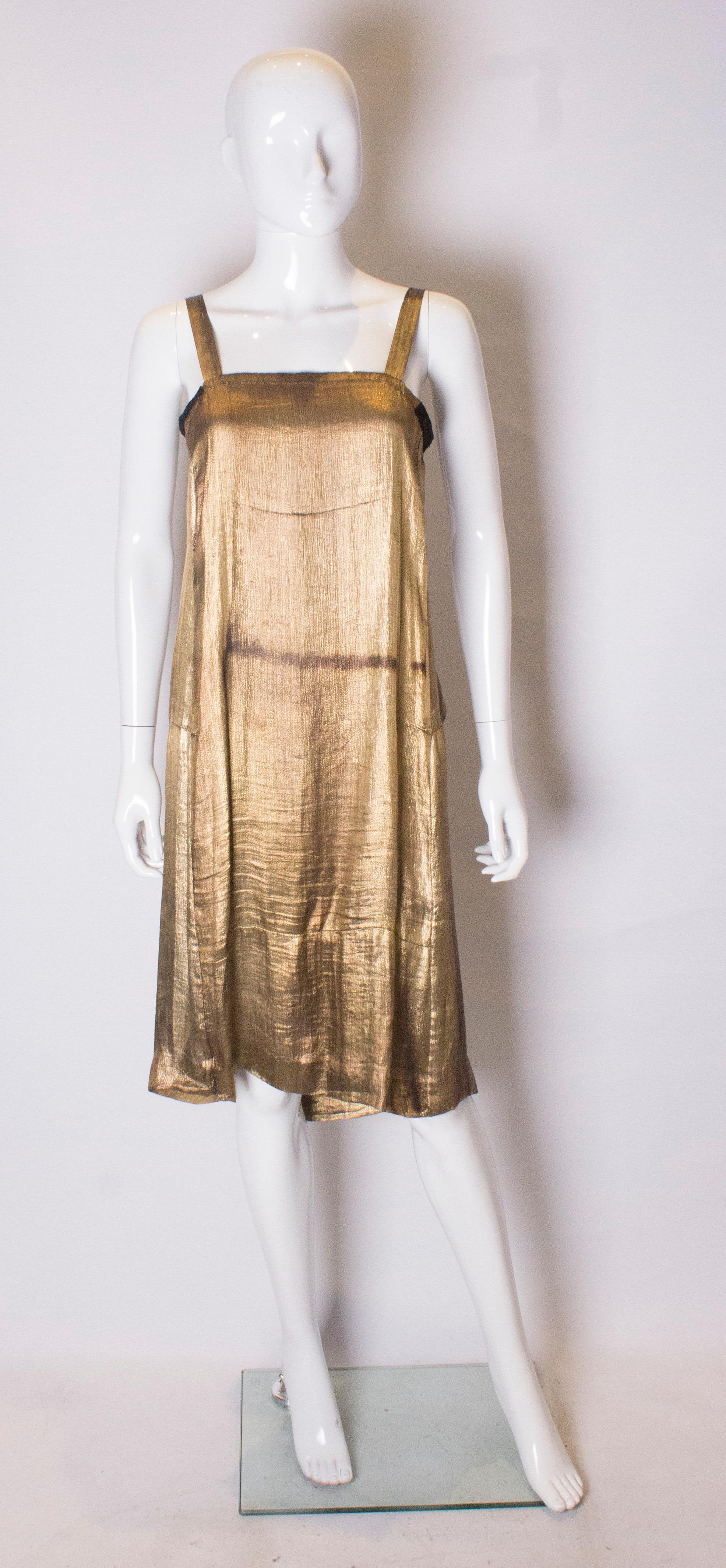 A super chic vintage gold lame dress from the 1920s.
The dress slips over the head and is in a lovely soft gold colour . There is a small amount of tarnishing .