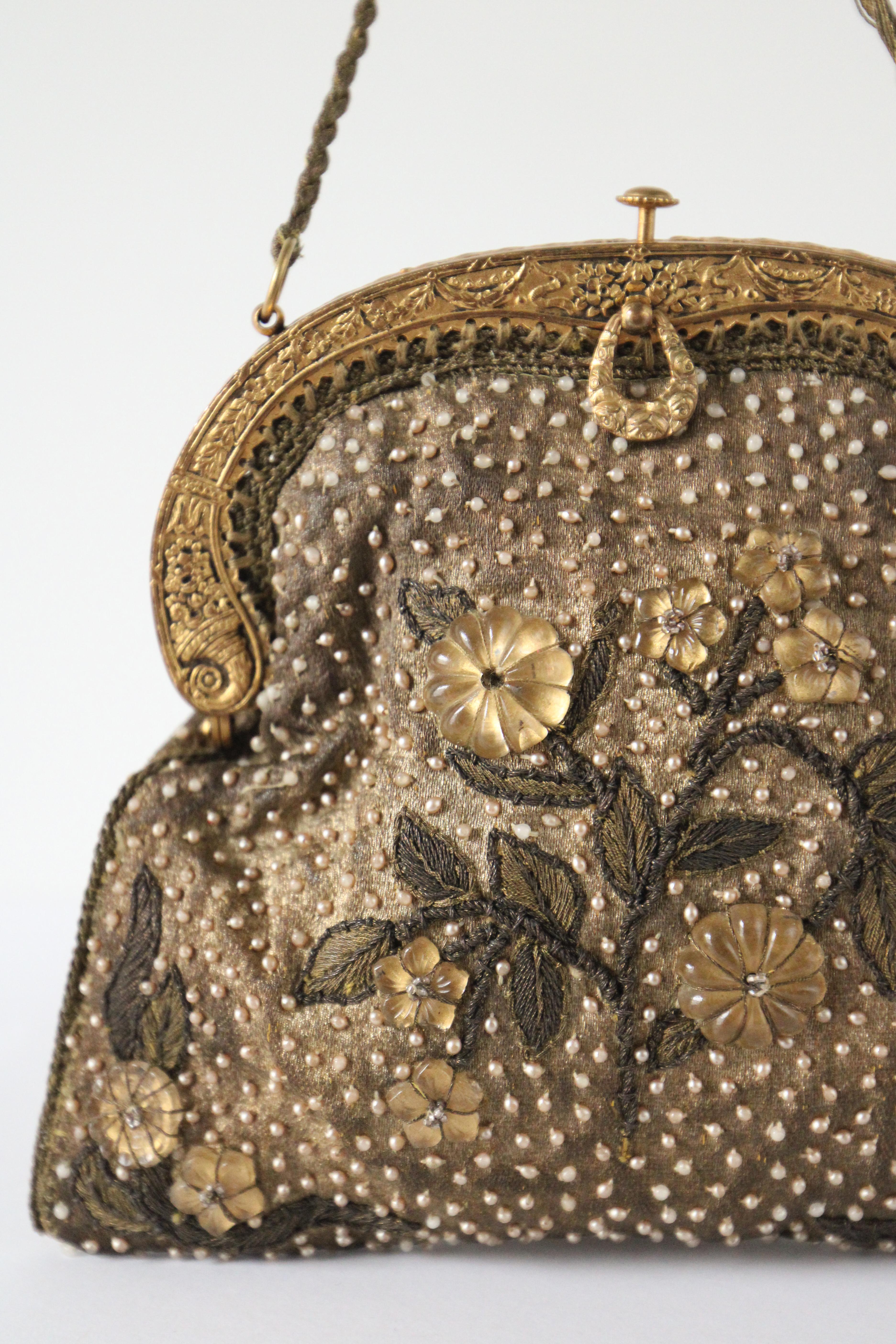 This truly magnificent 1920's French handbag, rendered in gold silk lamé and  embellished with a pattern of small pearlescent beads, is a marvel to behold. The front and reverse of the bag, are accented by gold silk lamé embroidery patterns along