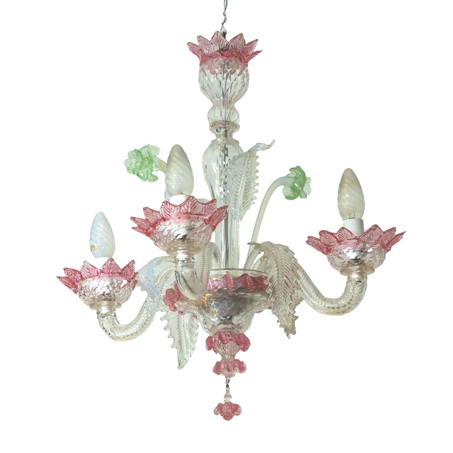 Un charmant lustre vintage en verre de Murano, fabriqué à la main en Italie, vers les années 1920. Ce petit luminaire à quatre lumières capture l'éclat caractéristique de la verrerie de Murano, réputée pour ses couleurs vives, son art complexe et sa