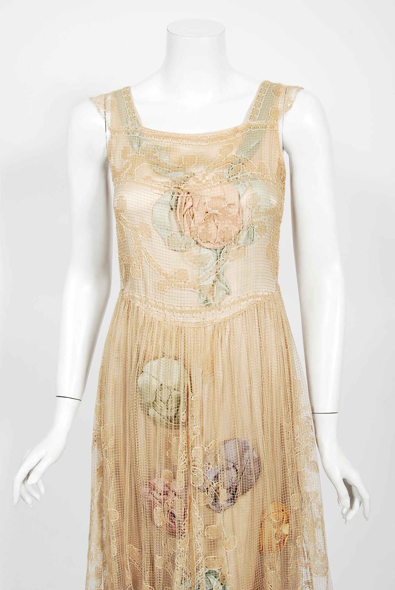 A breathtaking museum quality bridal dance dress dating back to the mid-1920's. Two layers are cleverly designed to complement each other; a fine filet-lace outer layer with a foliate design over an ecru silk-crepe slip layer embroidered with pastel