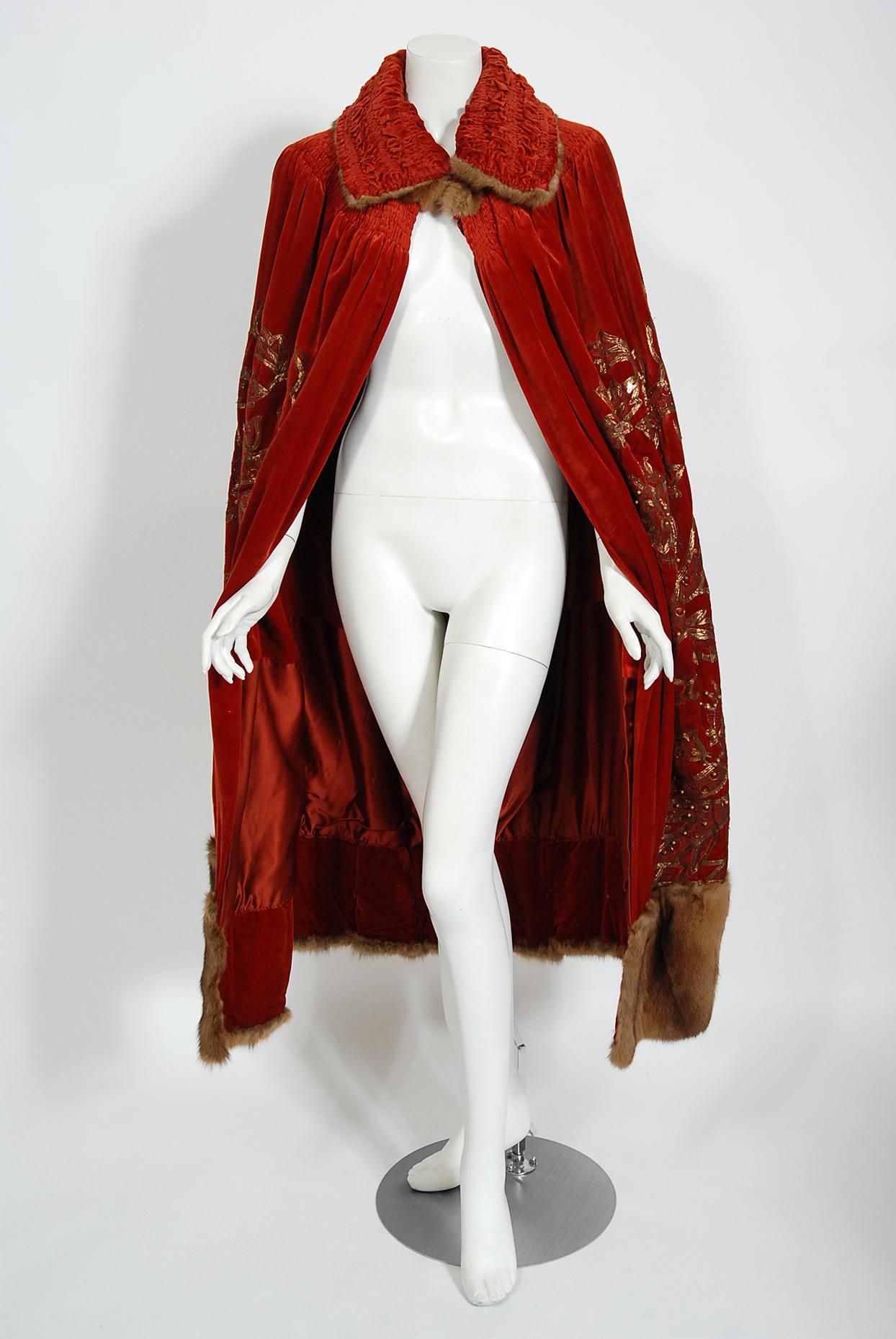 A truly breathtaking Frederick Loeser & Co museum quality metallic gold embroidered dark red silk-velvet cape dating back to the early 1920's. Frederick Loeser & Co was a high-end department store in Brooklyn, New York founded in 1860 by German