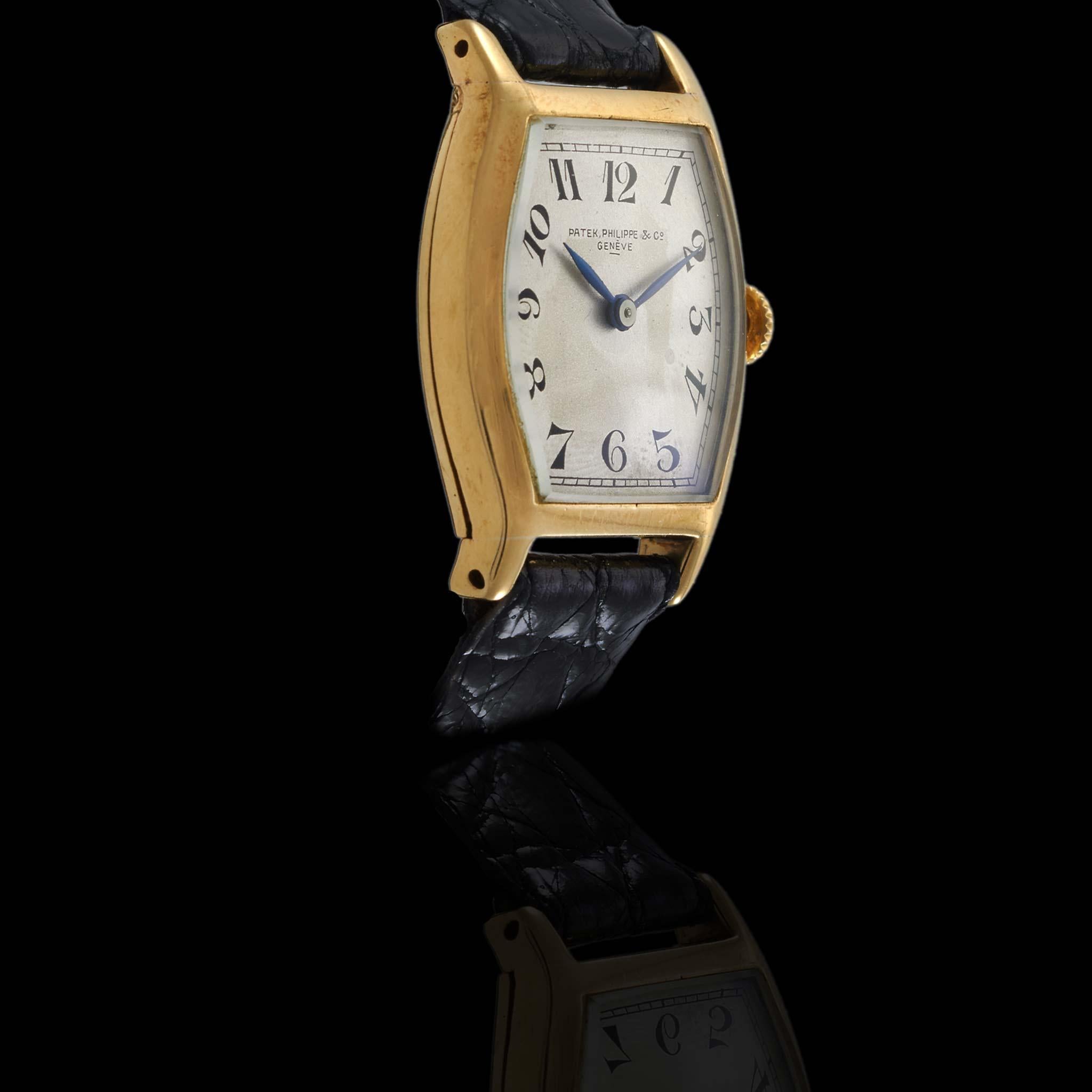 Un raro e precoce orologio da polso Patek Philippe del periodo Art Deco, intorno agli anni '20, con una cassa a forma di tonneau di 27 x 27 mm realizzata in oro giallo massiccio 18KT. Il quadrante argentato è dotato di indici in numeri arabi dipinti