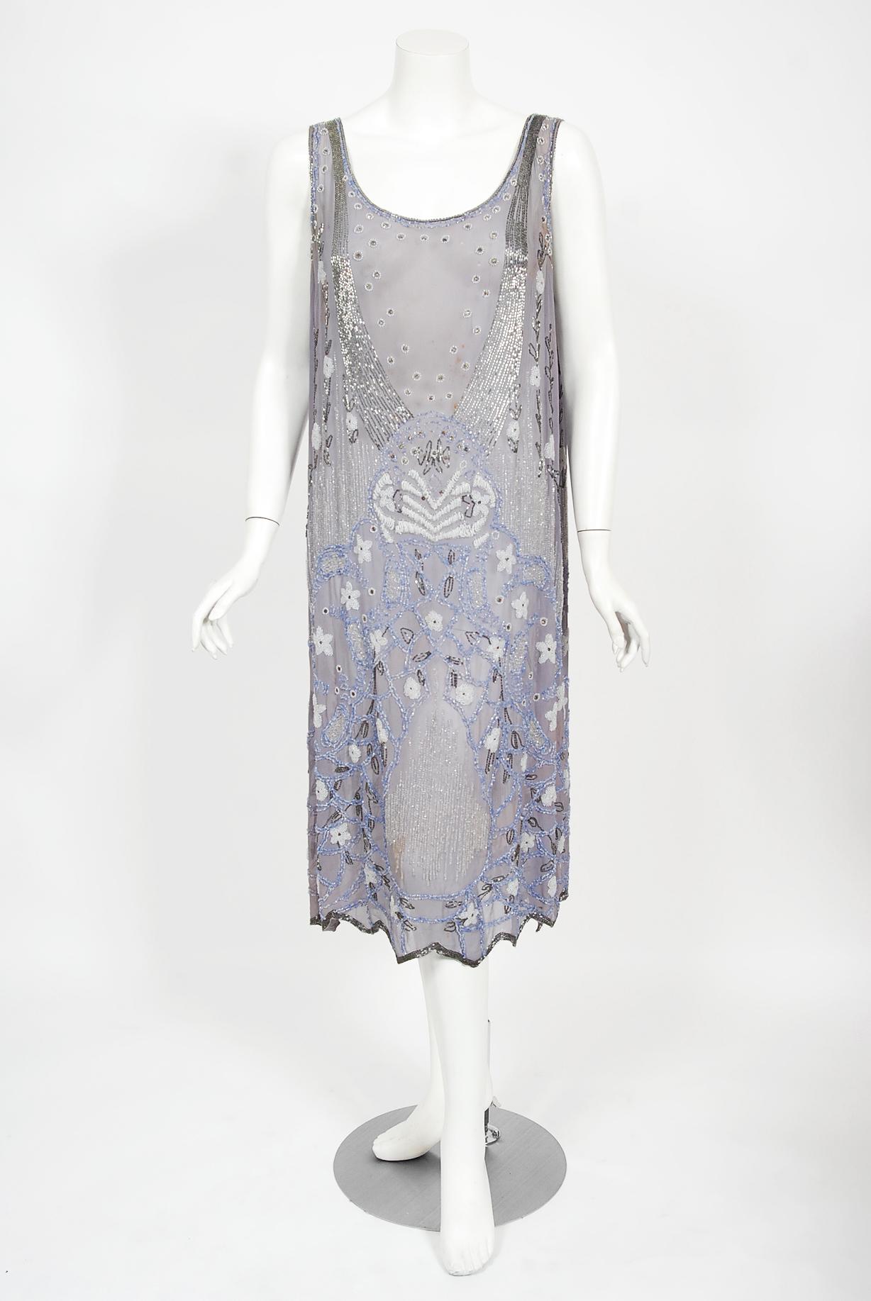 Romantic flapper dresses from the early 20th century are perennial favorites and this one is a show-stopper! The garment's simple unstructured style is so modern; the fine beadwork is a treasure trove of needle art. This beauty, fashioned from