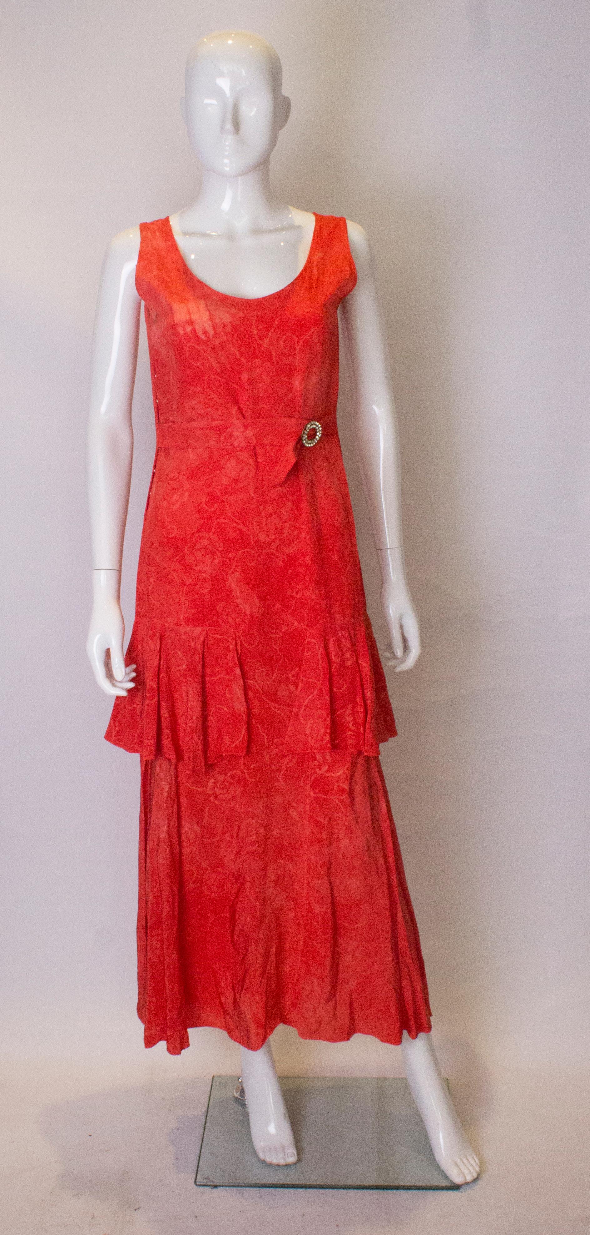 A pretty 1920s silk dress with a decorative belt. This  1920s silk dress has a drop waist with frill along the hip line. The belt ties at the waist with an attractive diamante buckle.