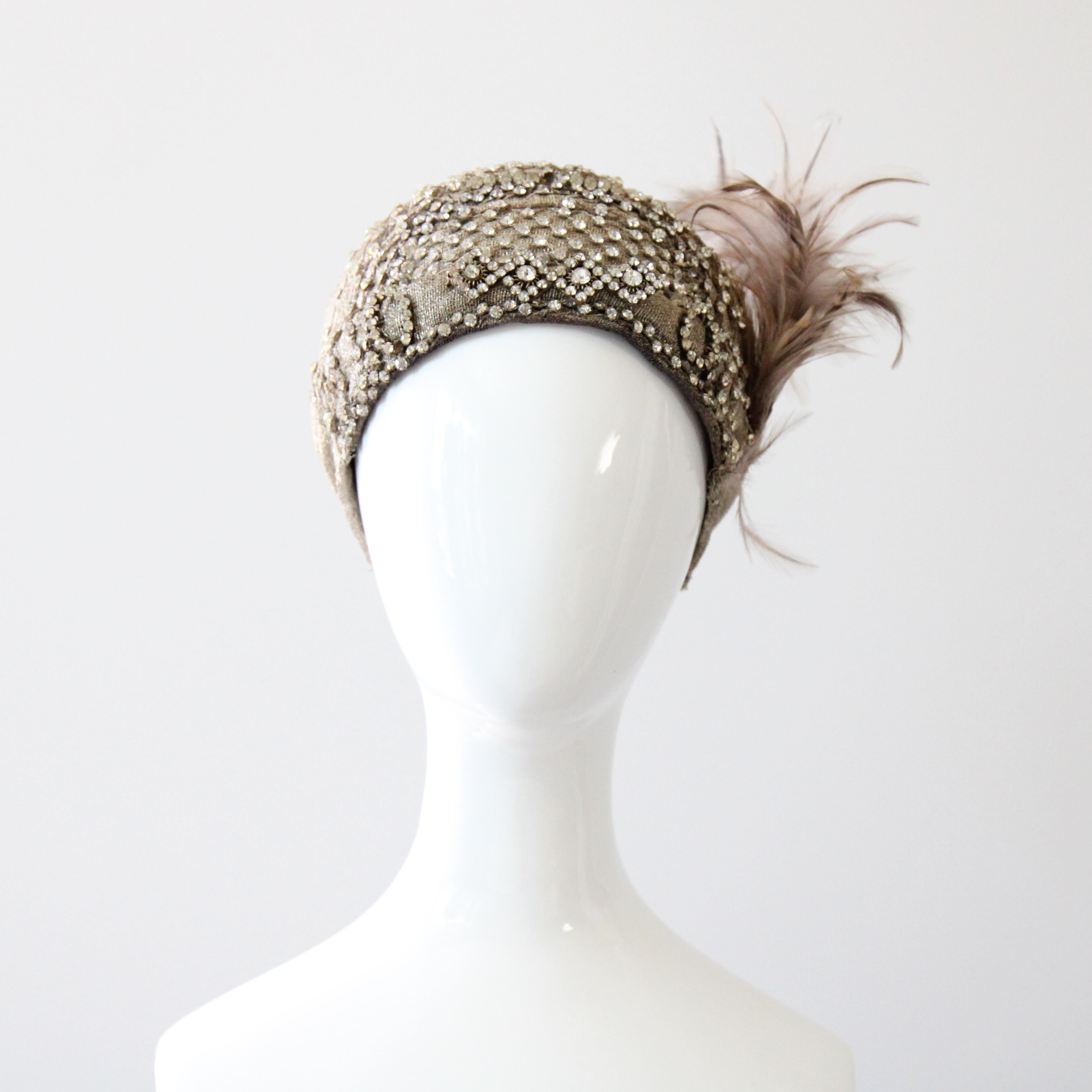 Questo raro e incredibilmente intricato cappello a cloche in lamé d'argento degli anni '20, costruito su una base interna in feltro modellato, su cui sono cuciti i pannelli in lamé, è una bellezza da vedere. Decorata con strass argentati incastonati