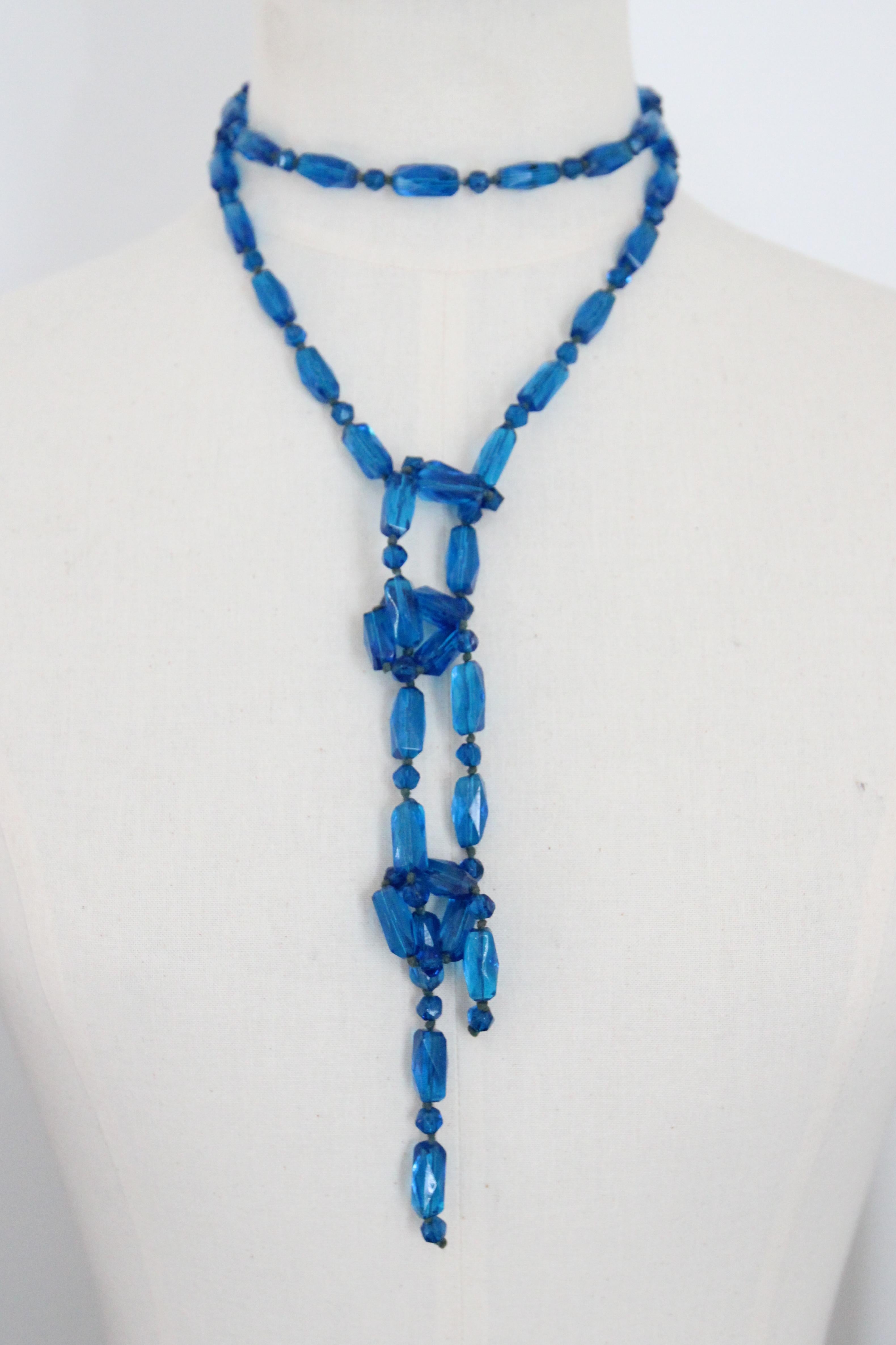This wonderfully eye-catching 1920's turquoise blue faceted glass beaded lariat necklace, is a rare piece to behold.

The elegant length boasts a pattern of faceted tubular glass beads and rounded faceted beads interspaced by hand knotted