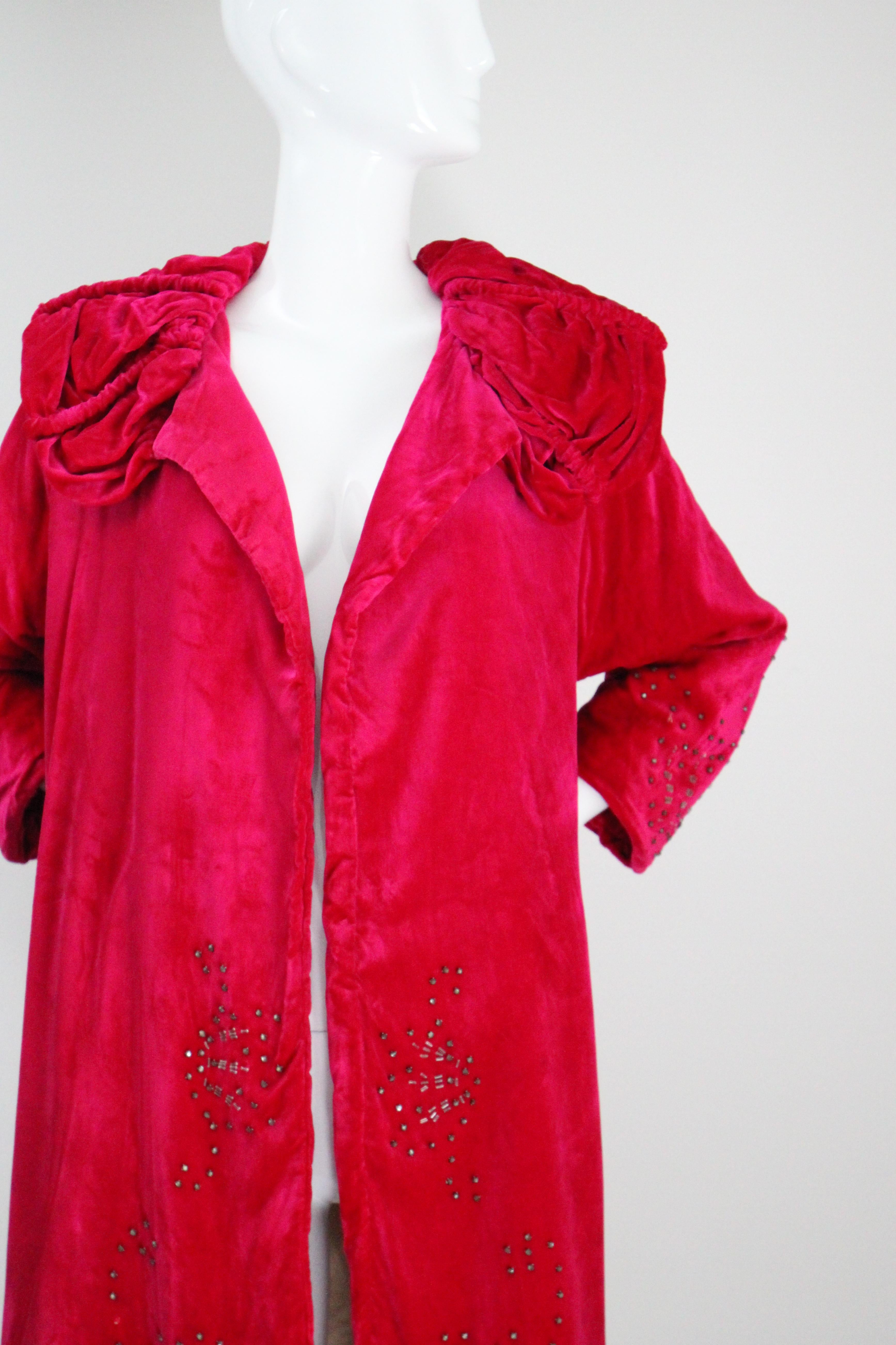 Dieser originale Seidensamtmantel aus den 1920er Jahren in einem leuchtenden Himbeerrosa und mit silbernen Strasssteinen und silbernen Glasperlen verziert ist ein seltenes Stück, das man nie wieder findet,  ist das perfekte Accessoire für Ihre