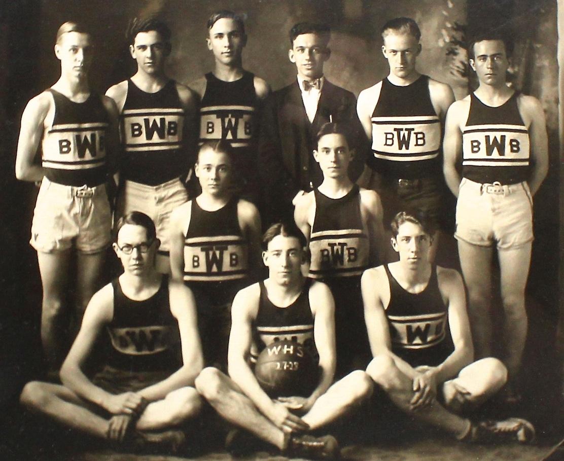This is an vintage photograph of a 1928 basketball team. The team's basketball is marked 