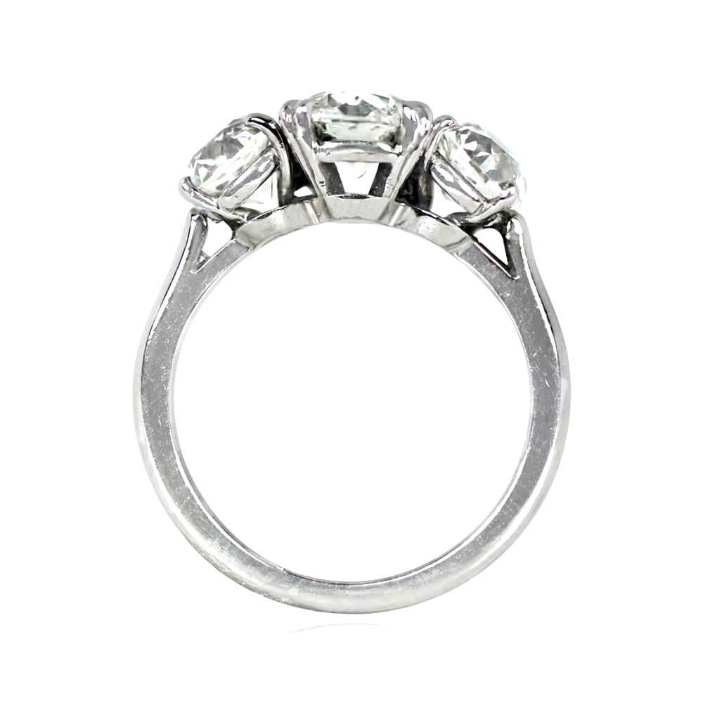 This vintage three-stone engagement ring, crafted in platinum circa 1950, showcases old European cut diamonds set in prongs. The 1.29 carat center diamond has J color and VS1 clarity, while the two side diamonds have a combined weight of 1.64