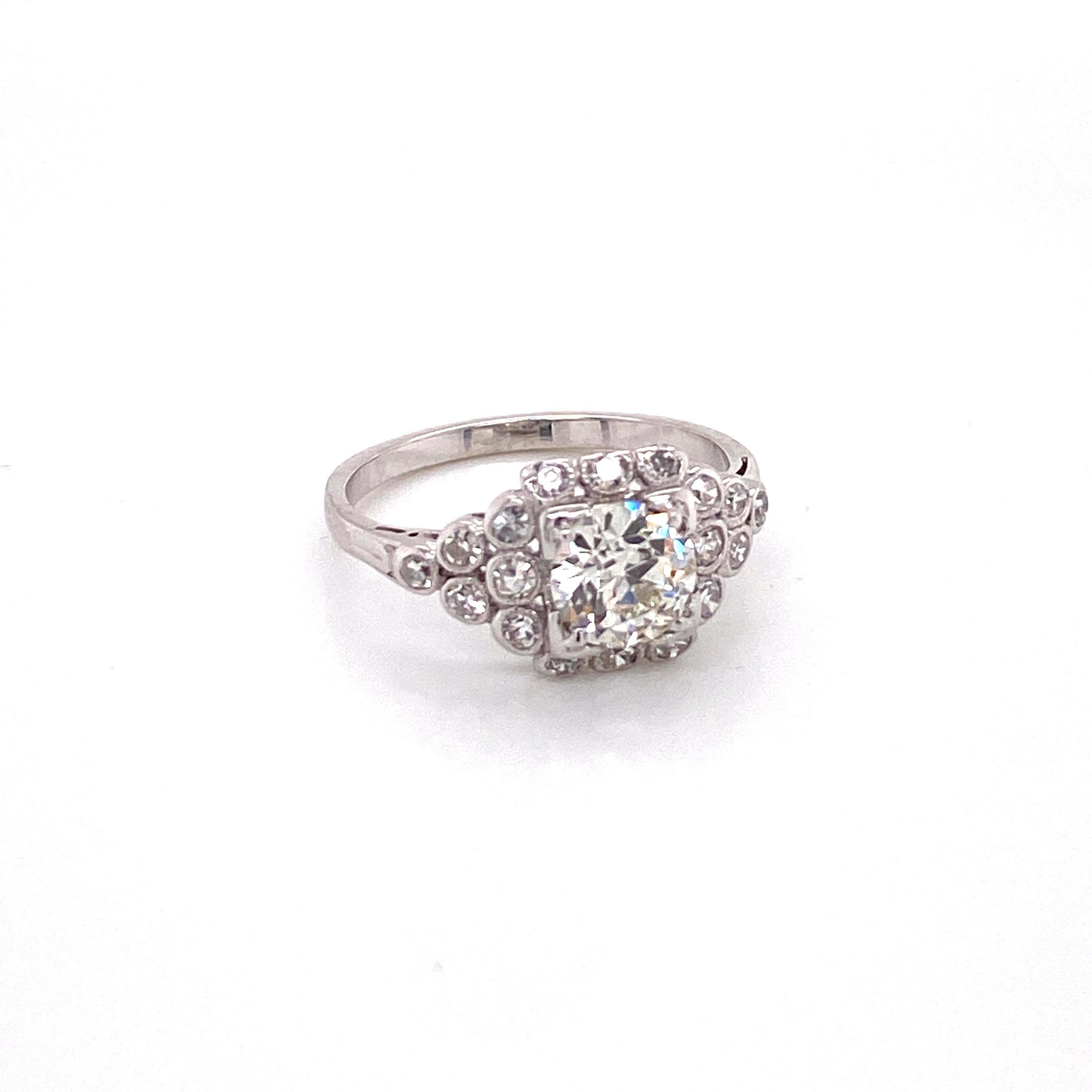 Vintage 1930s European Cut Diamond Platinum Ring with Bezel Set Halo - The center European Cut diamond weighs 1.00ct and is color J with clarity VS1. The diamond dis set in a square prongs surrounded by bezel set 12 single cut diamonds which creates