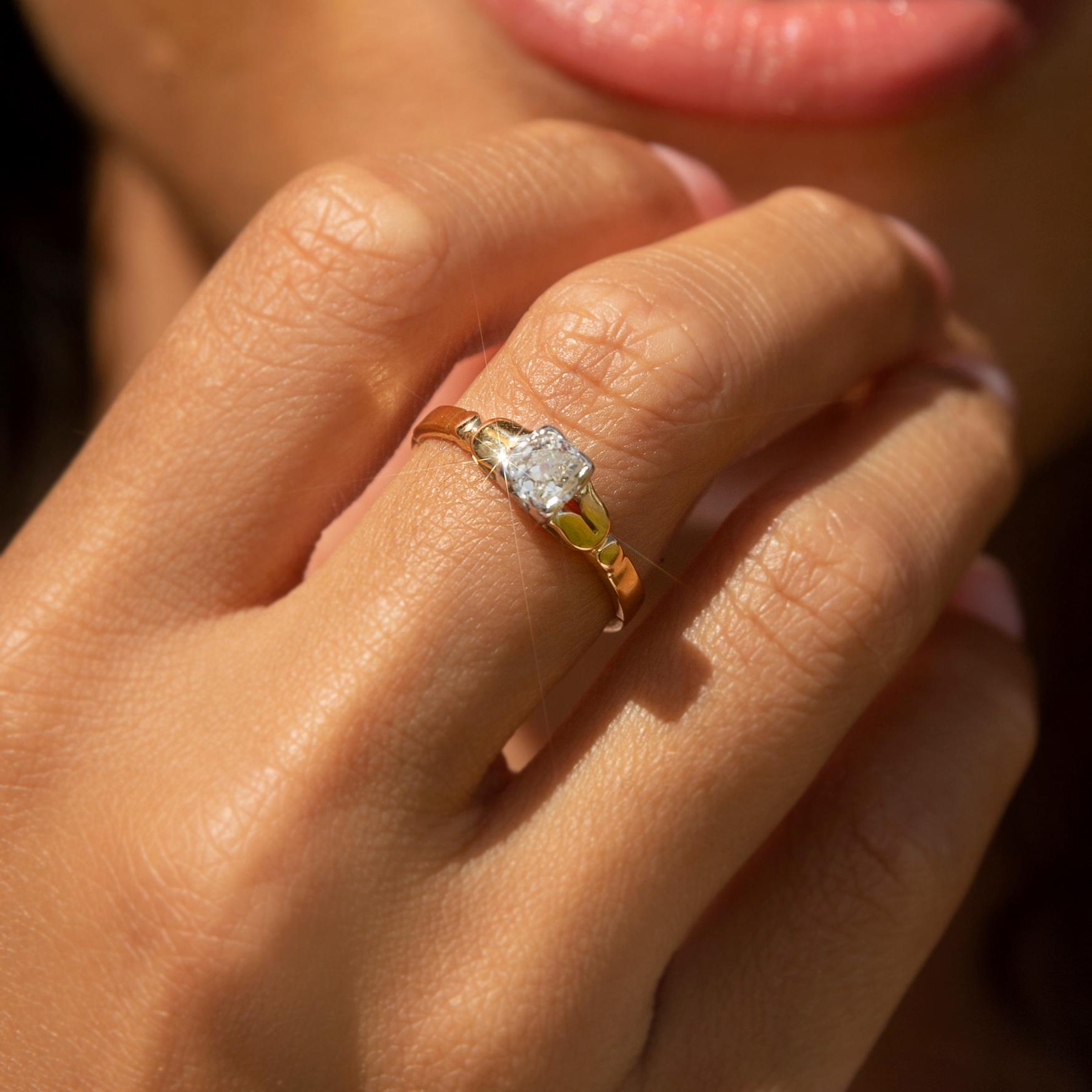 Crafted in 18 carat gold, this adorable vintage ring, circa 1930s, features a delightful Old Mine Cut diamond in an elegant white gold partial rubover setting on a gleaming yellow gold band. She has been named The Cindy Ring. Her simple yet elegant