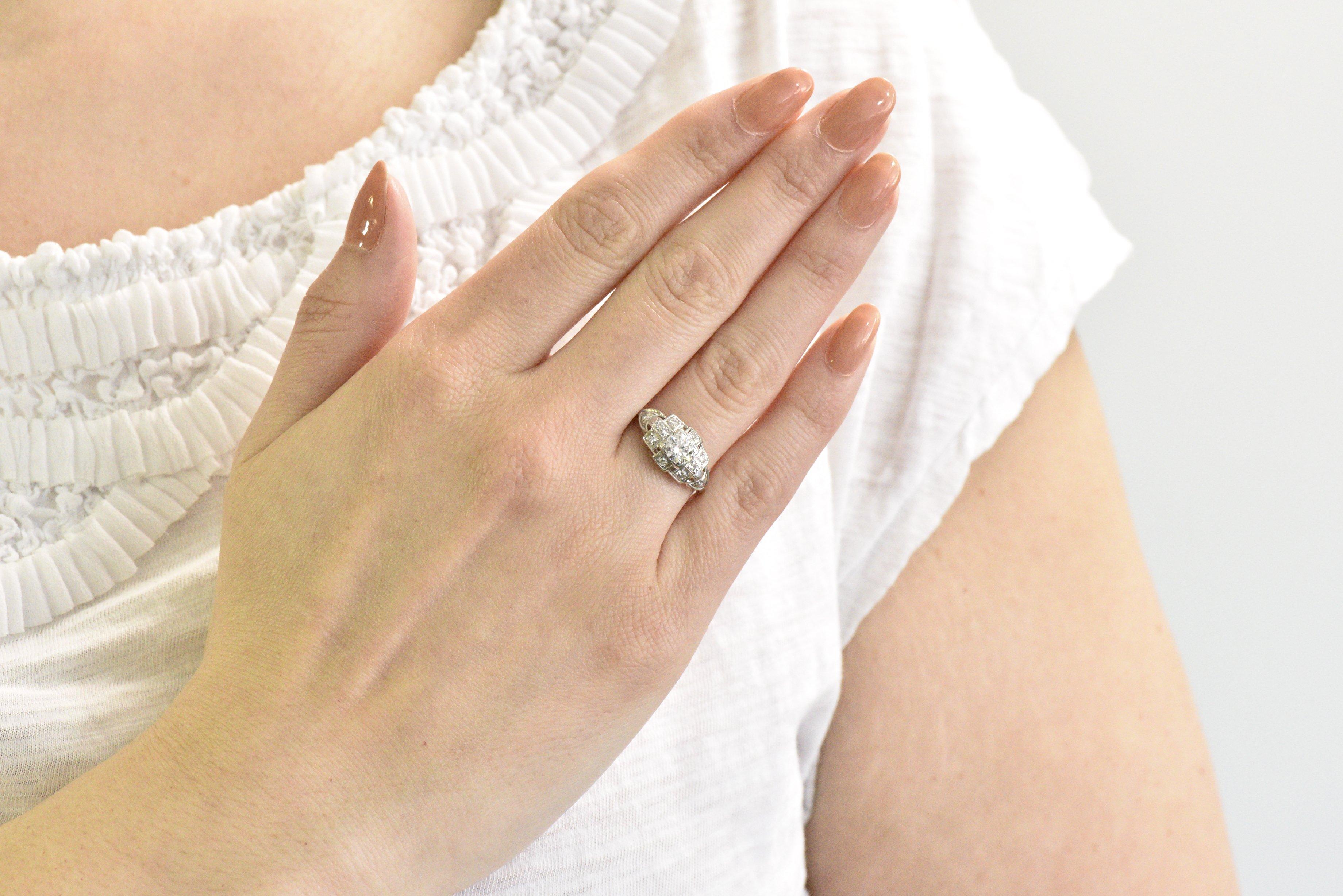 Engagement ring designed as a fun geometric design comprised of squares and stylized triangular shoulders

Centering a transitional cut diamond weighing approximately 0.50 carat, G color with SI1 clarity

Accented throughout by single cut diamonds