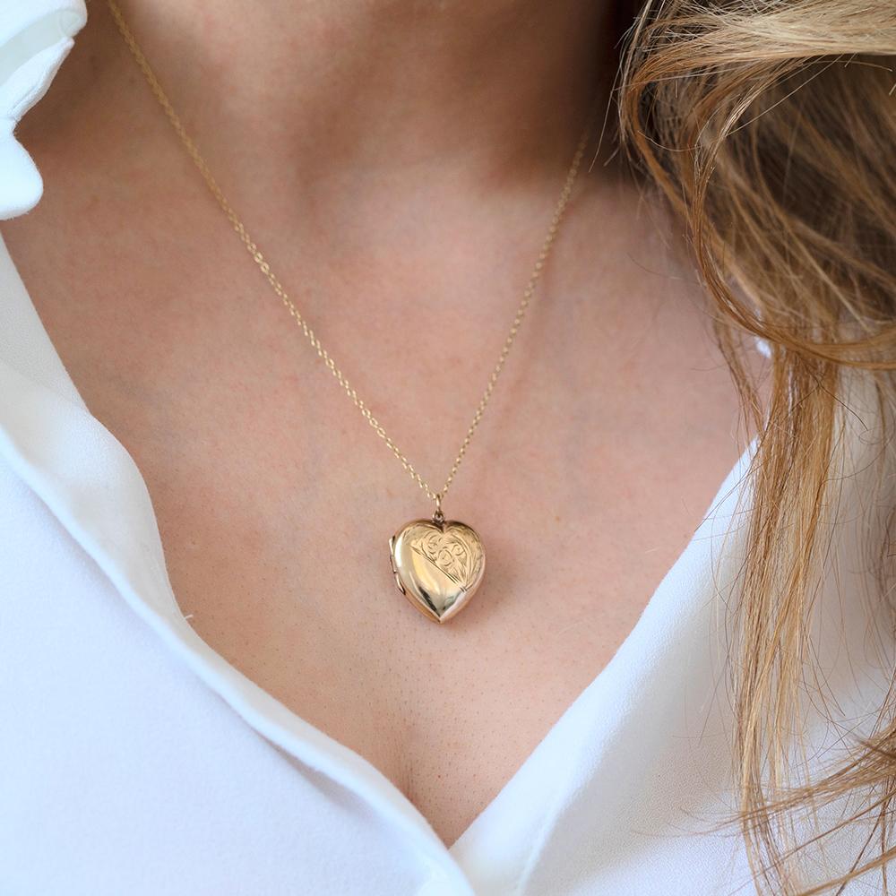 This charming vintage heart locket necklace is crafted in 9ct yellow gold and features a simple, polished front and reverse, with a soft domed shape that reflects the warmth of the metal. The back is clearly stamped “9CT BACK & FRONT”, indicating