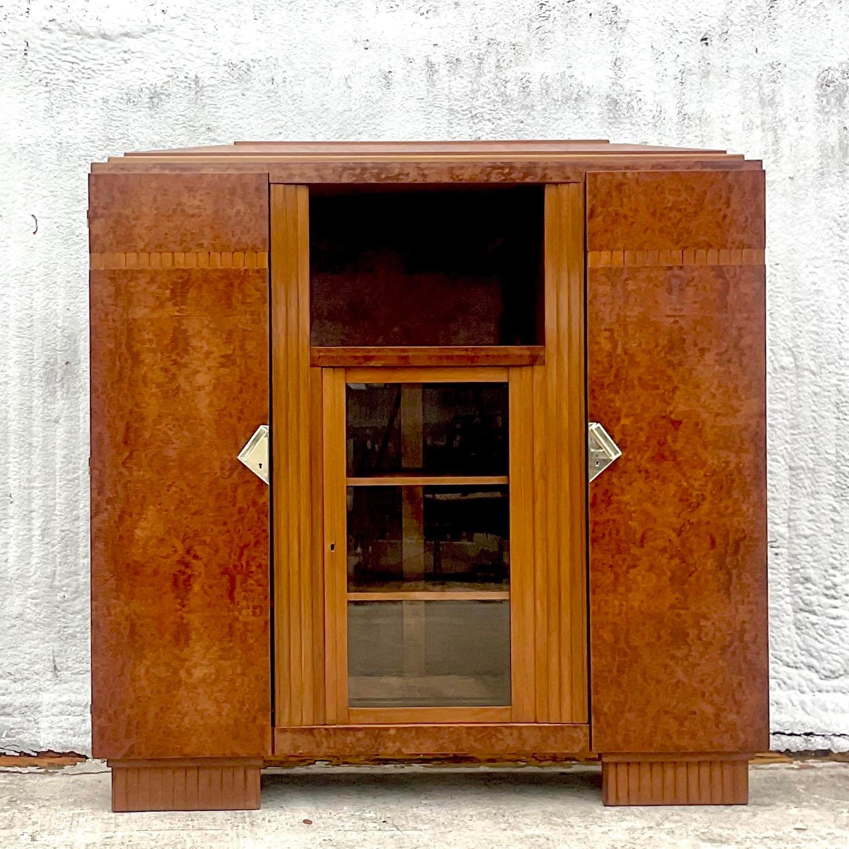 A fabulous vintage French Art Deco armoire. A beautiful Burl wood cabinet with inset glass door. Lots of great interior storage. Polished nickel hardware. Tagged Desborne Paris. Acquired from a Palm Beach estate.