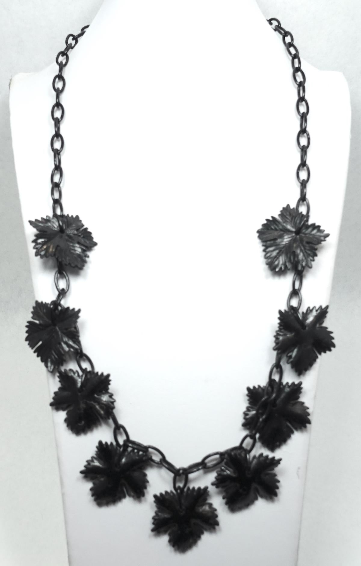 This vintage 1930s necklace has carved black celluloid leaves on a link chain with a hook closure.  In excellent condition, this necklace measures 27” long and each leaf is 1-3/8” x 1-3/8”.