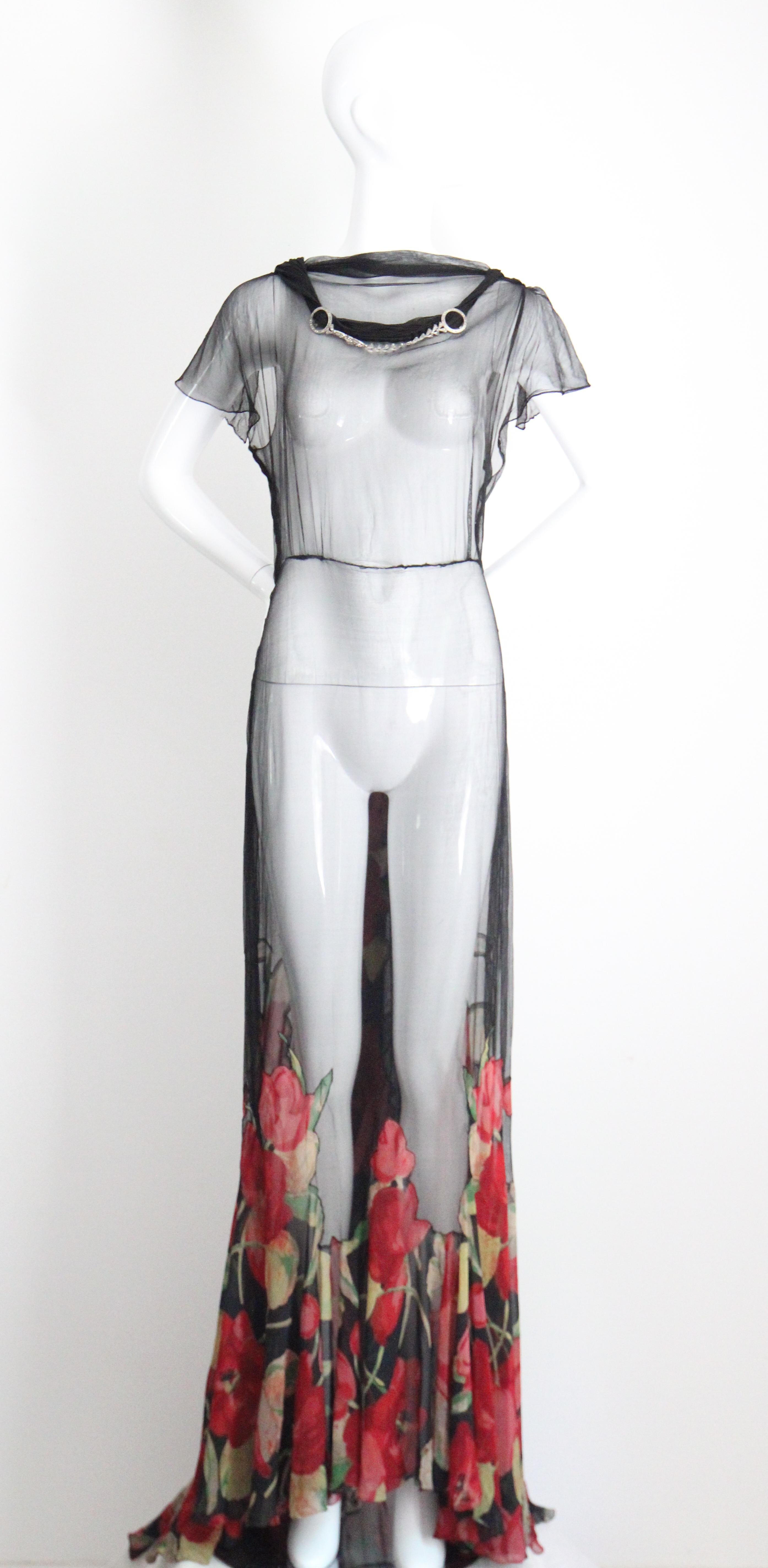 A marvel to behold, this original vintage 1930's black cotton voile and silk chiffon evening gown, decorated with a silver rhinestone inlay metal chain, is a rare piece to behold.

The bateau cut neckline is accented by a soft pleated feature, which