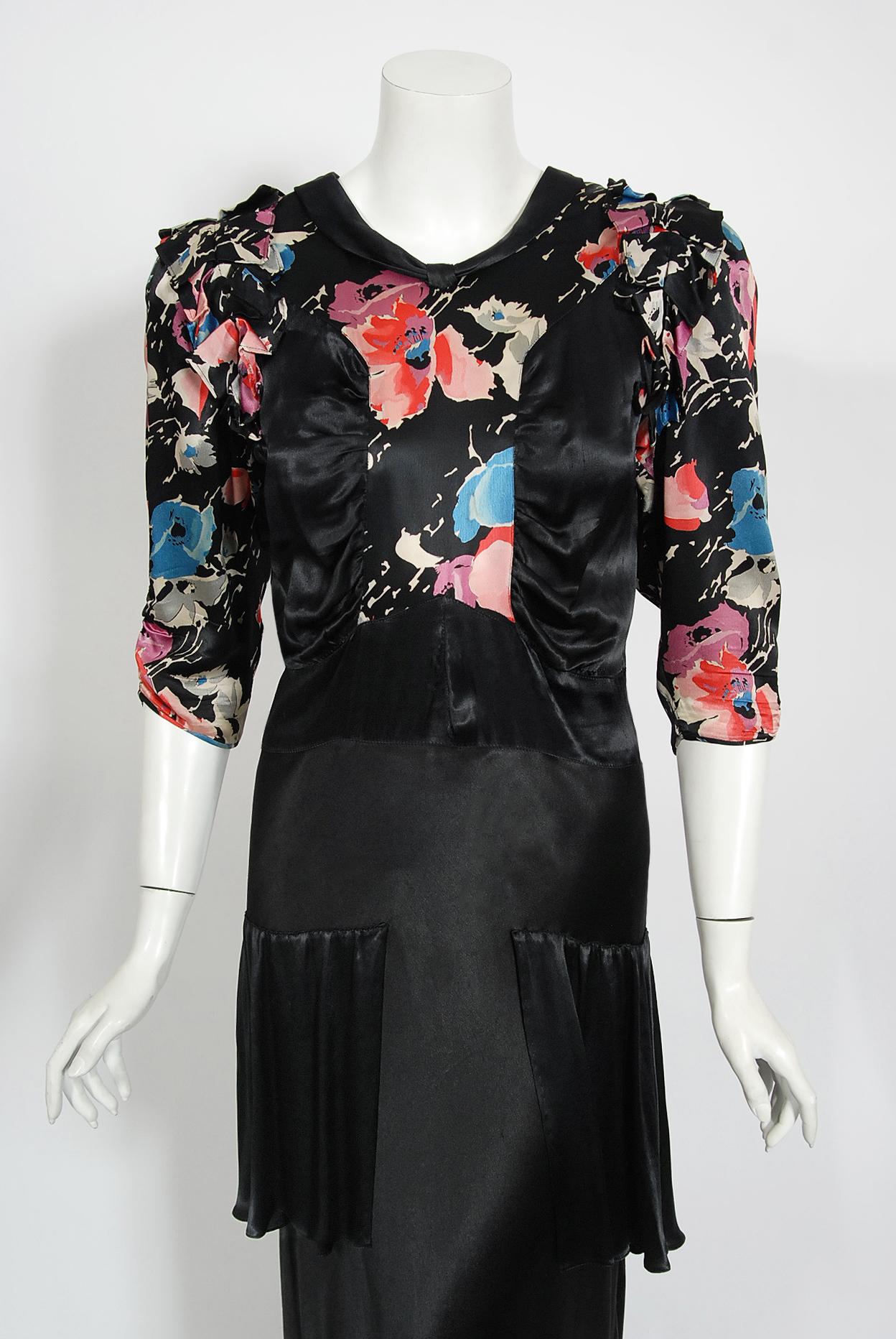 An extraordinarily stunning and exceptional 1930's black floral print liquid silk satin bias-cut gown. Old Hollywood glamour at it's finest! The bodice has the most flattering gathered side-panel design with chic 3/4-length sleeves that have a