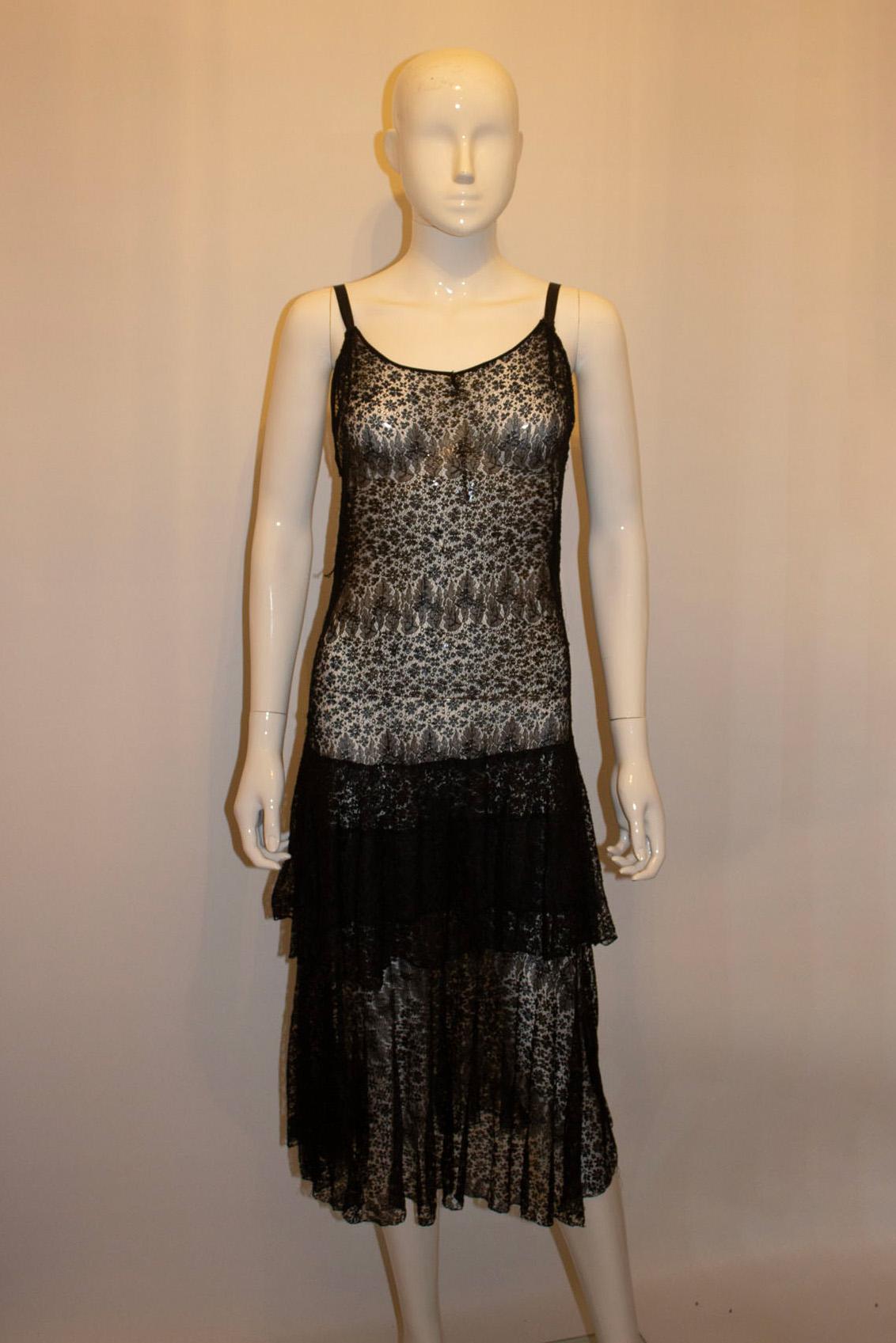 A wonderful  black lace evening dress , dating from the 1930s.  The dress would  be ideal for a party or dancing.
It has black ribbon straps. 
Measurements; Bust up to 38''. length 36''