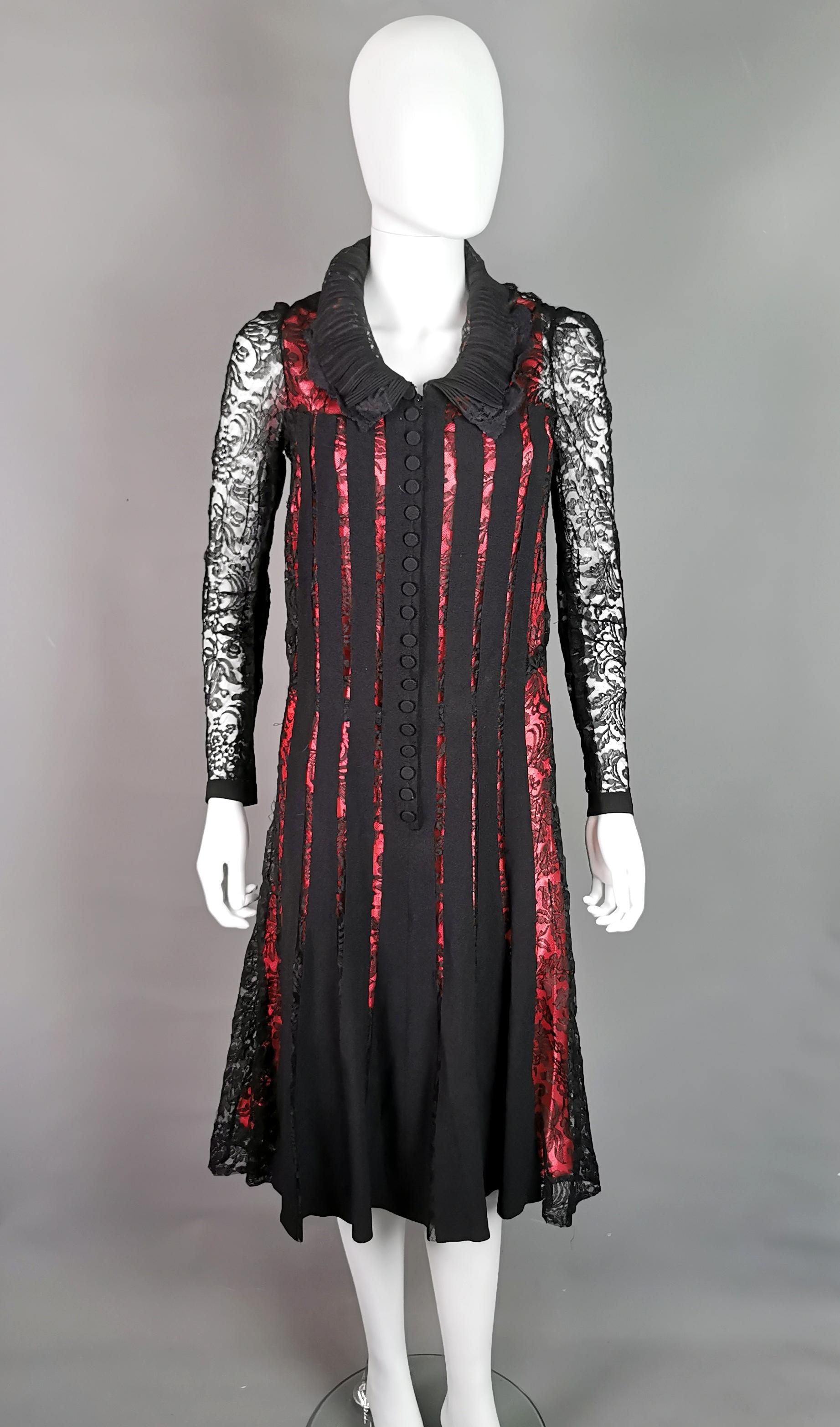 A rare vintage c1930s evening dress.

A black lace overdress with a metal zipper up the front and black taping to the front and back.

The dress has long sleeves which taper down and buttons at the cuffs, slightly nipped in at the waist with an a