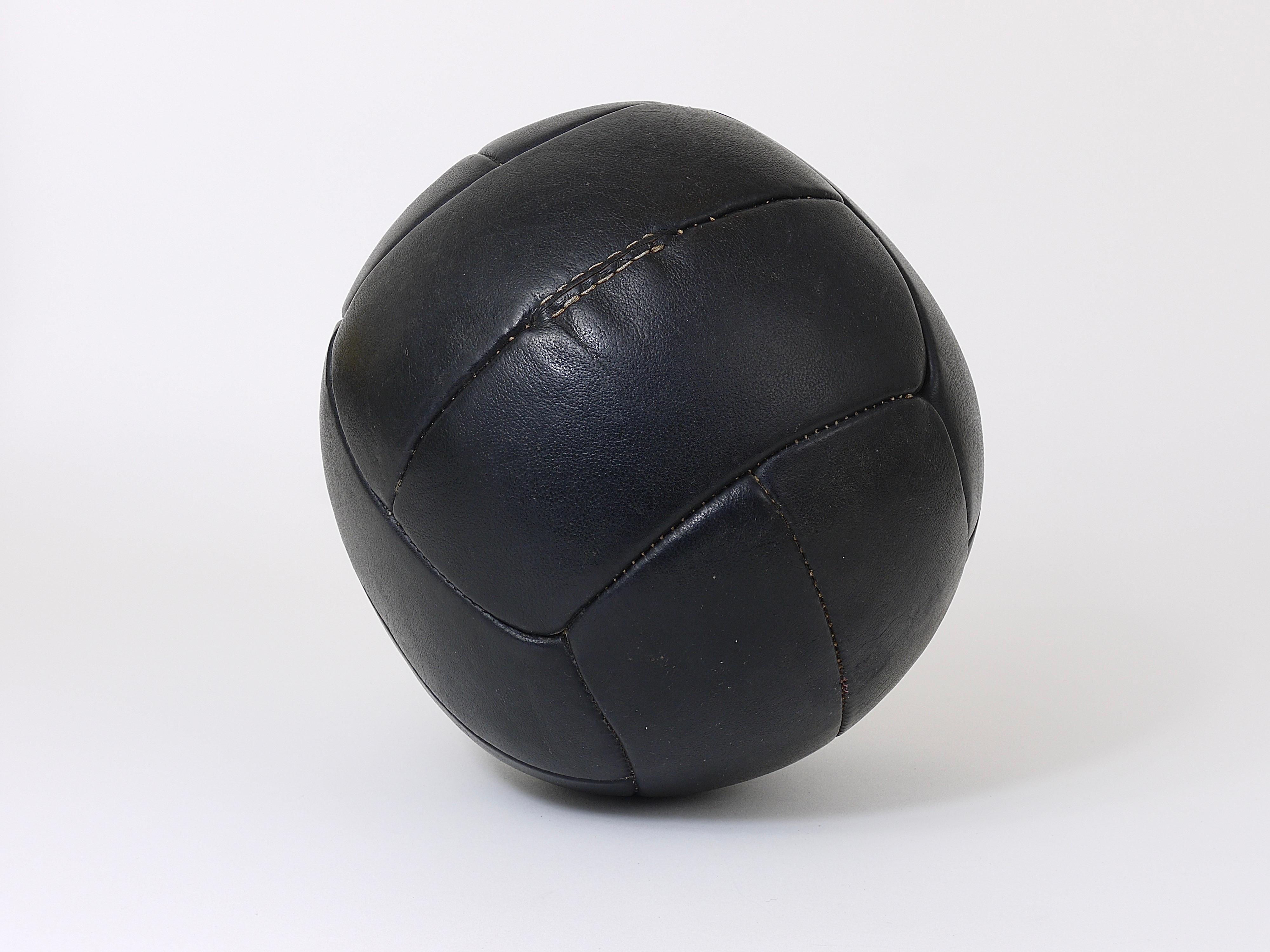 A decorative handcrafted medicine ball from a Czech gym, dated circa 1930s. Made of thick black saddle leather in good vintage condition with charming patina. Cleaned and treated with special leather care. Measure: Diameter 11 inches, weight 3 kg /